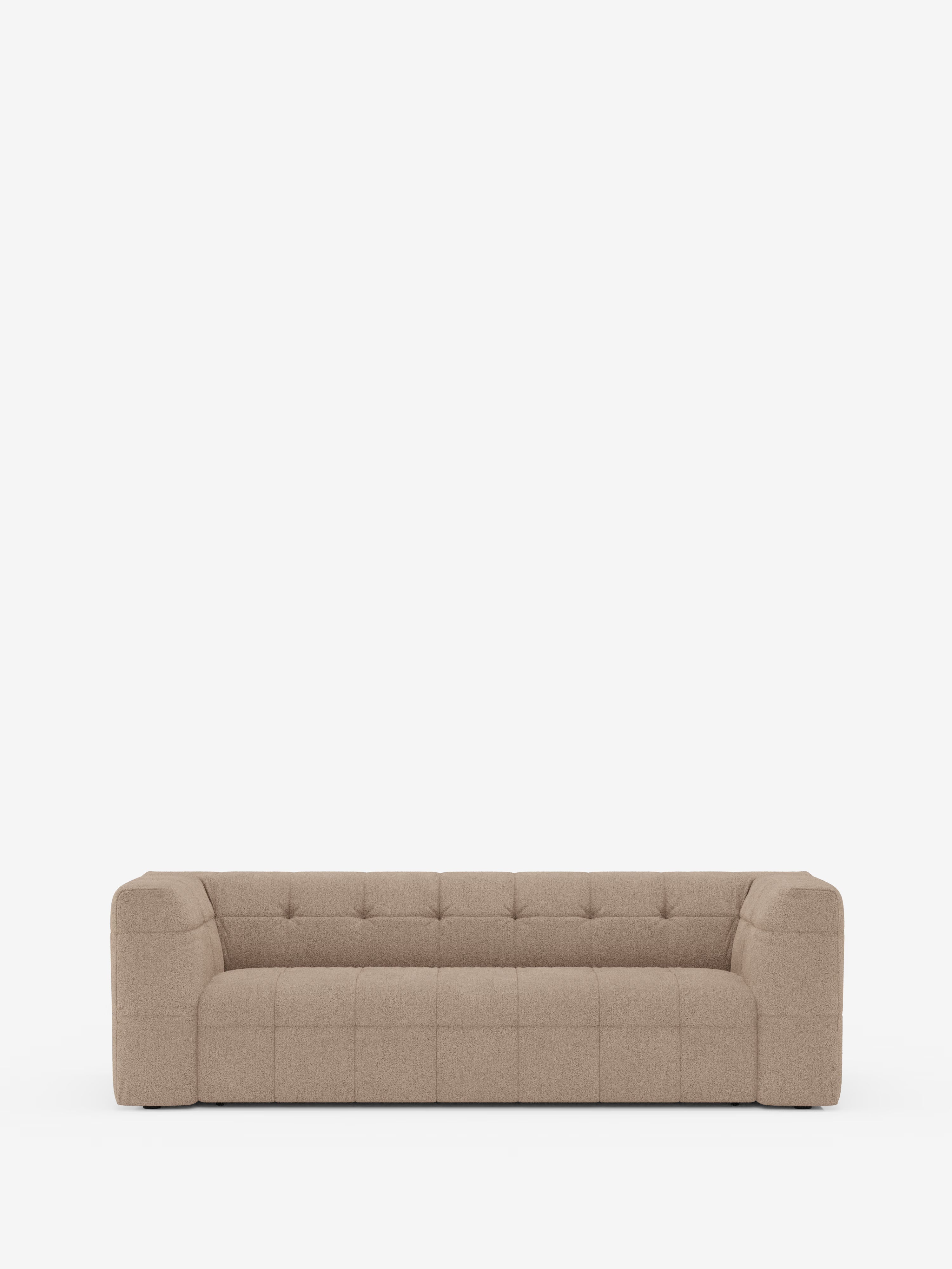 Un divano moderno e dal profilo basso di Divani.Store — il divano modulare Mosaic a 3 e 4 posti in bouclé — spicca su uno sfondo bianco a tinta unita. Questo divano modulare presenta braccioli larghi e squadrati e un design minimalista dalle linee spigolose, con cuciture a griglia a vista sul rivestimento in tessuto T21 antimacchia e sulla seduta e sullo schienale trapuntati.