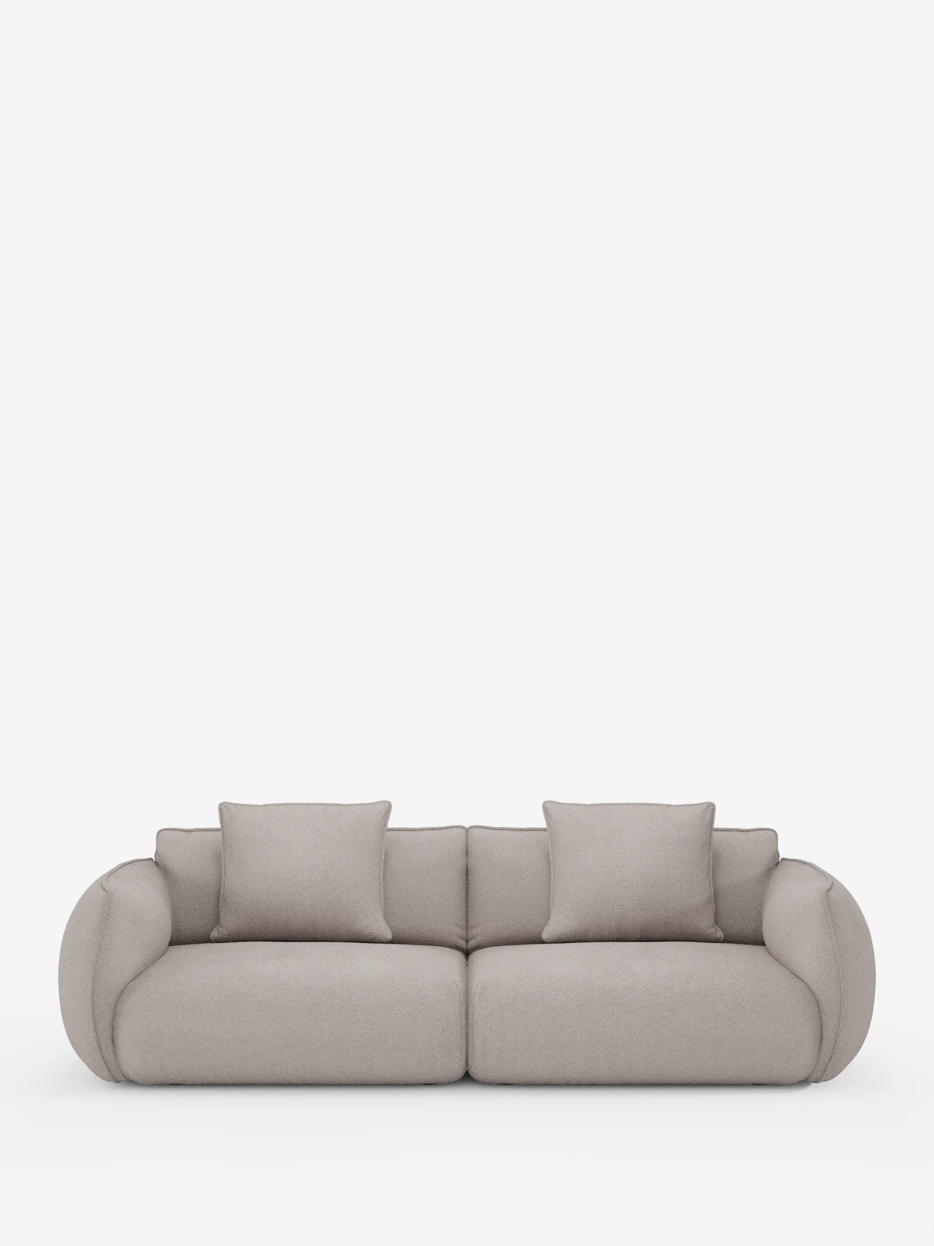 Il divano modulare e componibile a 3 posti Nimbus da 250 cm di Divani.Store, rivestito in tessuto T33 effetto cotone beige chiaro e resistente alle macchie, presenta braccioli e schienale arrotondati, sedute imbottite e spesse e due cuscini quadrati coordinati, il tutto su uno sfondo bianco a tinta unita.