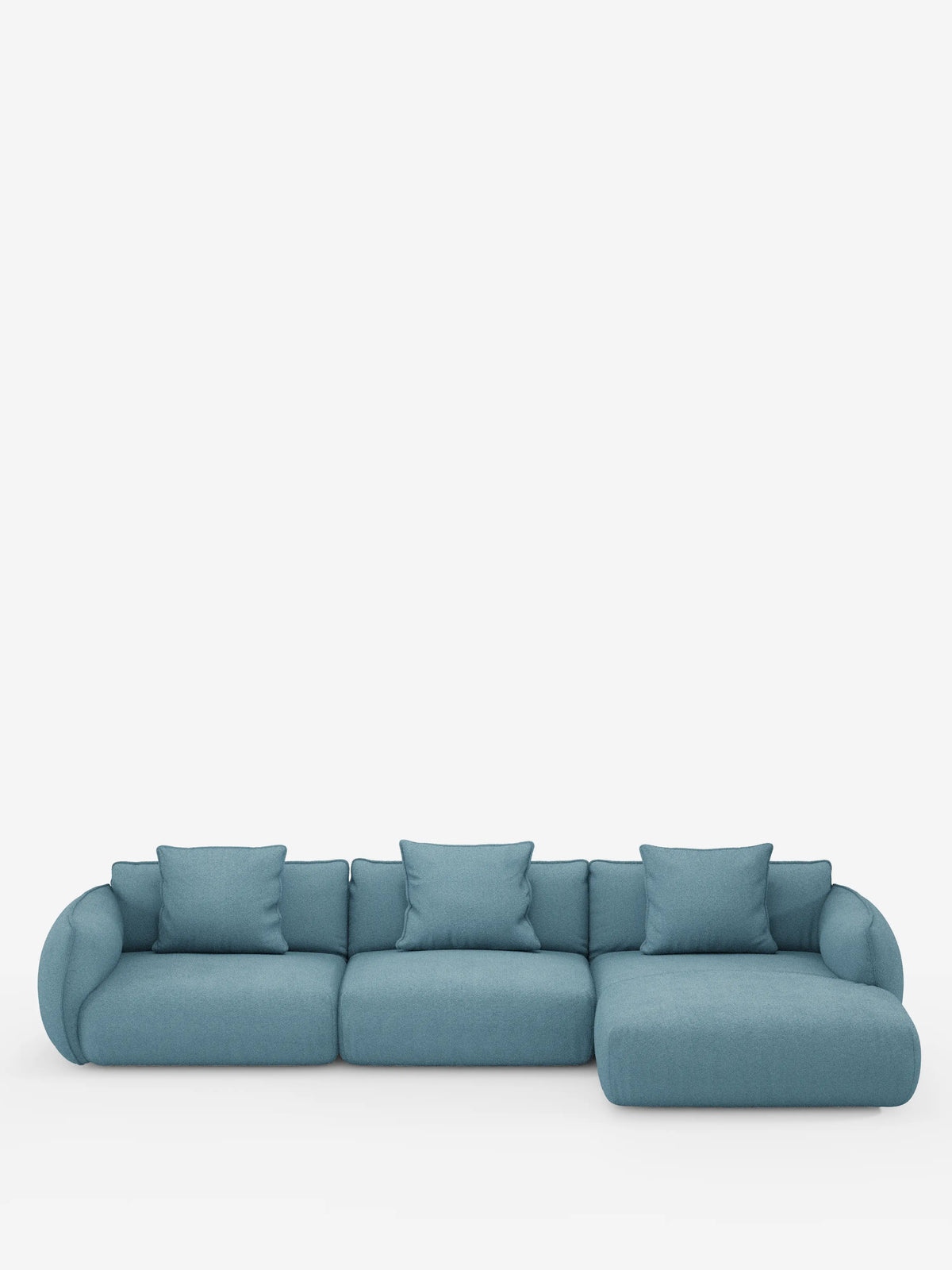 Un “Nimbus divano angolare con penisola componibile in morbido tessuto effetto cotone smacchiabile T33” di Divani.Store, rivestito in blu, con tre posti e una chaise longue a destra, presenta braccioli arrotondati e include cinque cuscini quadrati abbinati, il tutto in primo piano su uno sfondo bianco.