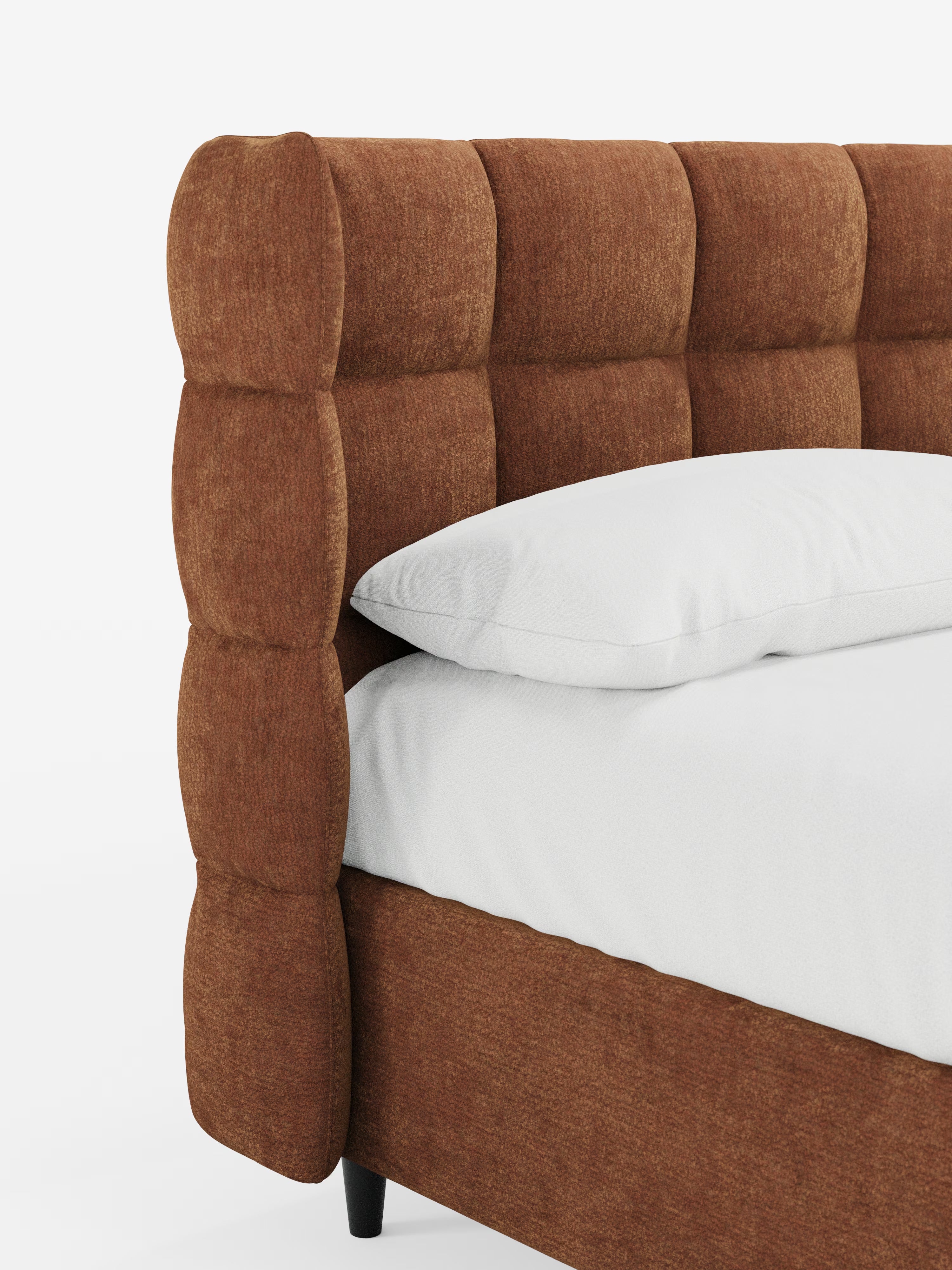 Primo piano del letto imbottito RAGNAR con contenitore e testiera capitonné avvolgente di Letti.store, rivestito in un elegante tessuto certificato Oeko-Tex®. Questo letto di grande stile presenta una raffinata testiera capitonné e morbidi pannelli laterali, impreziositi da cuscini e biancheria da letto bianchi. Il design è completato da gambe cilindriche corte di colore nero, mentre lo sfondo bianco a tinta unita mette in risalto la ricca trama e i dettagli sofisticati del letto.
