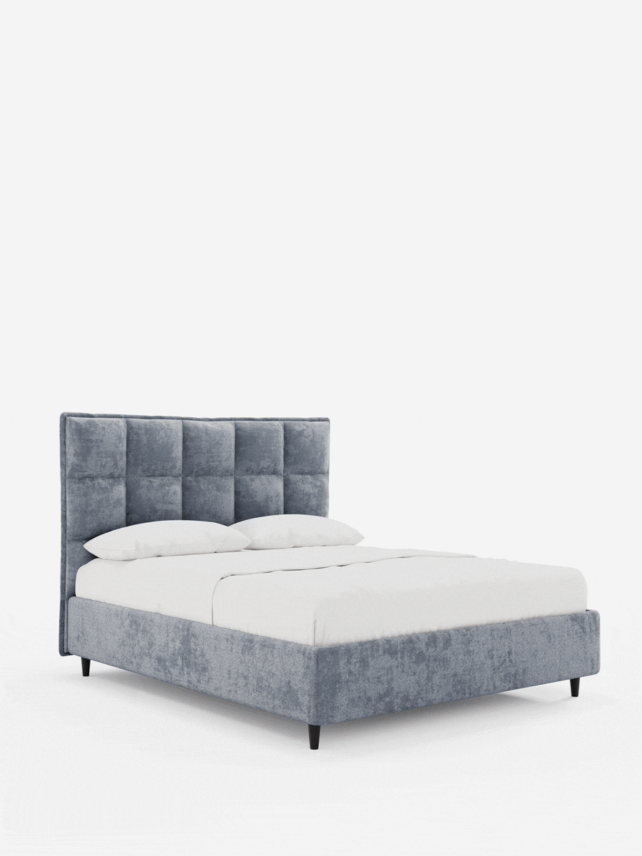 Letto imbottito AURO con contenitore e testiera alta capitonné in ciniglia Oeko-Tex® in morbido velluto grigio, caratterizzato da una testiera con trapuntatura a quadrati, biancheria da letto bianca e una struttura bassa con gambe affusolate scure.
