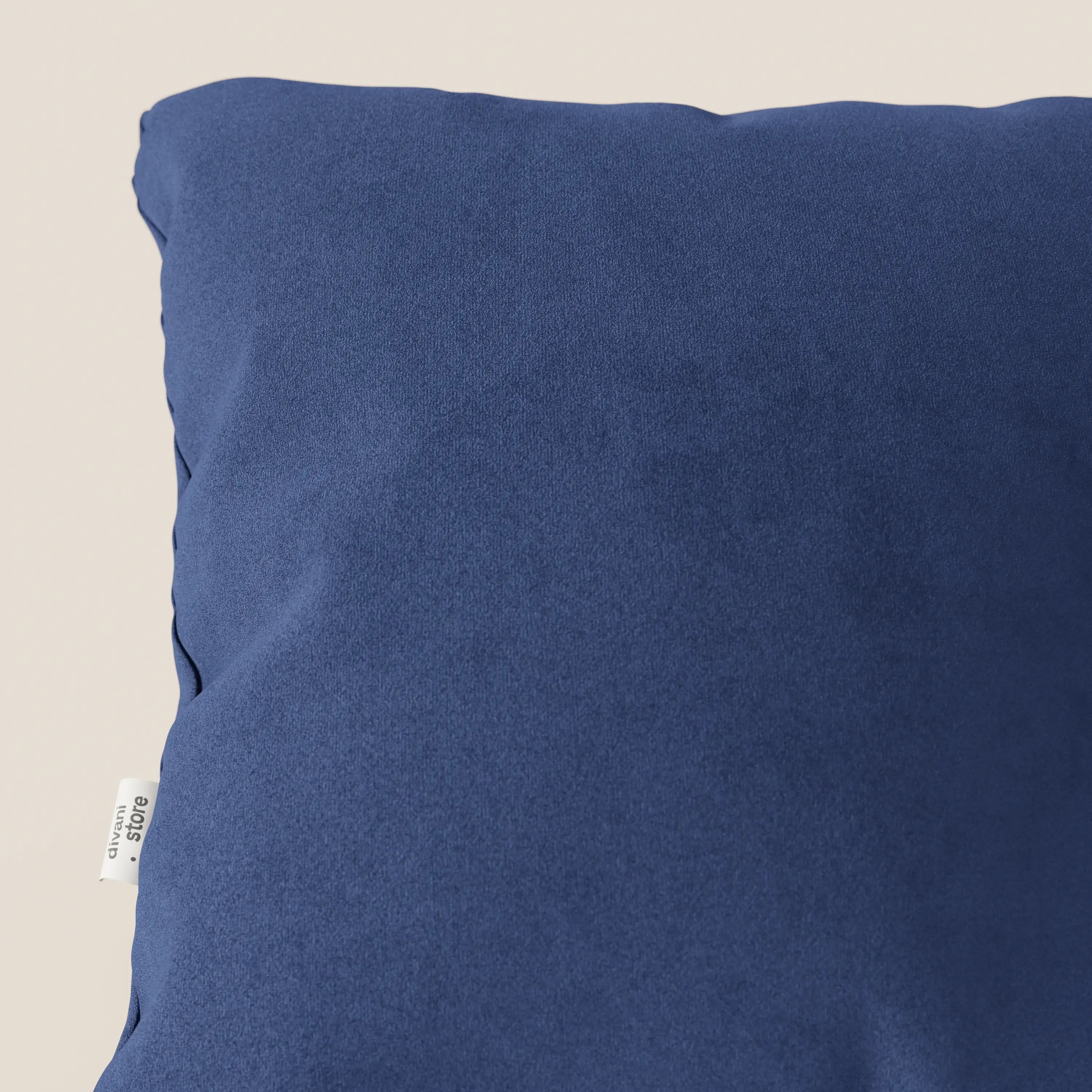 Primo piano del cuscino Jazz di Divani.Store in T11 blu, un cuscino quadrato di colore blu scuro in microfibra tecnica antimacchia, presentato su uno sfondo beige chiaro con una piccola etichetta in tessuto bianco cucita nella cucitura sinistra.