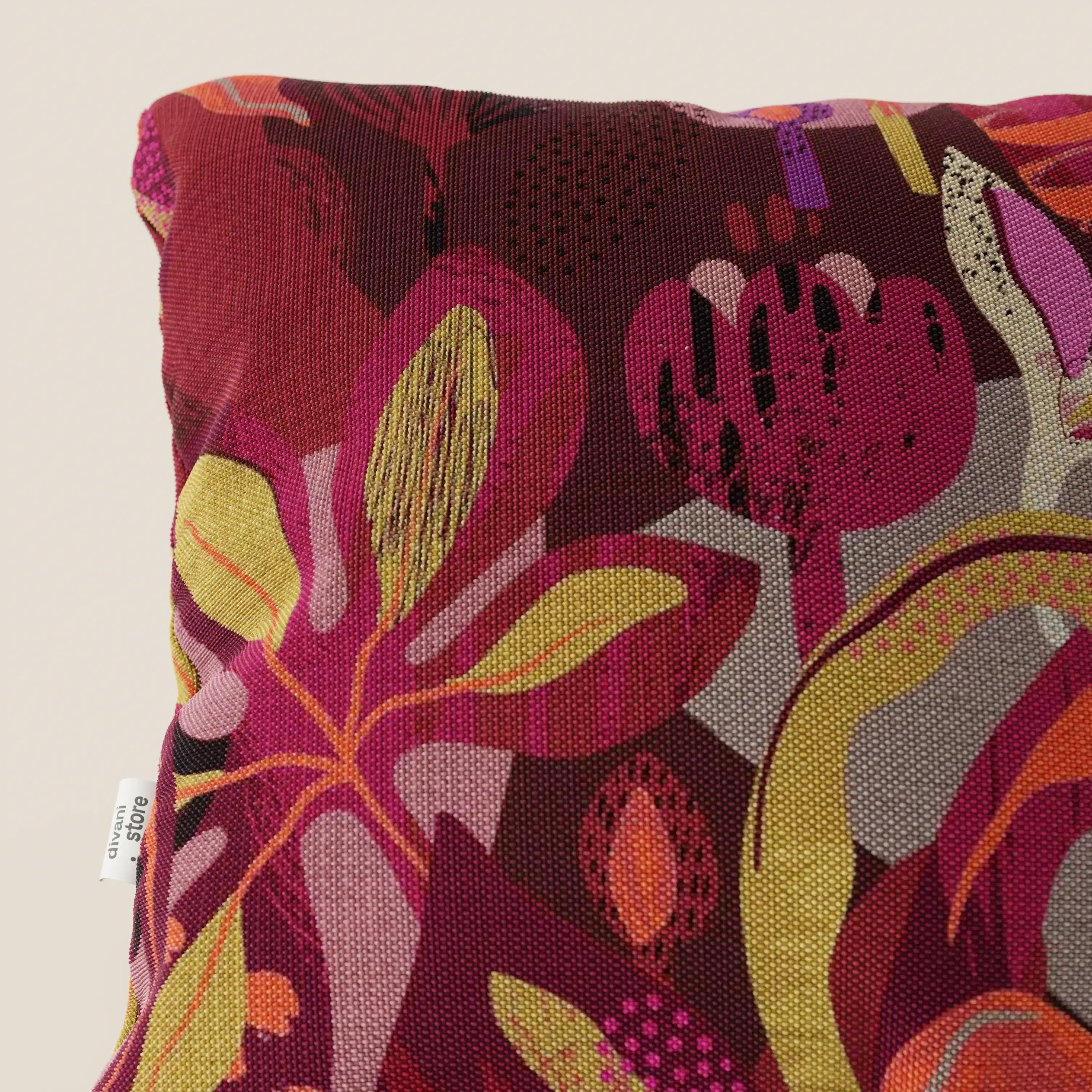 Primo piano del cuscino Joy collezione 45x45 cm di Divani.Store, caratterizzato da una vivace fantasia floreale multicolore sul rosso, in fresco cotone impermeabile. Elegante e pratico, è di facile manutenzione tra i cuscini lavabili in lavatrice.
