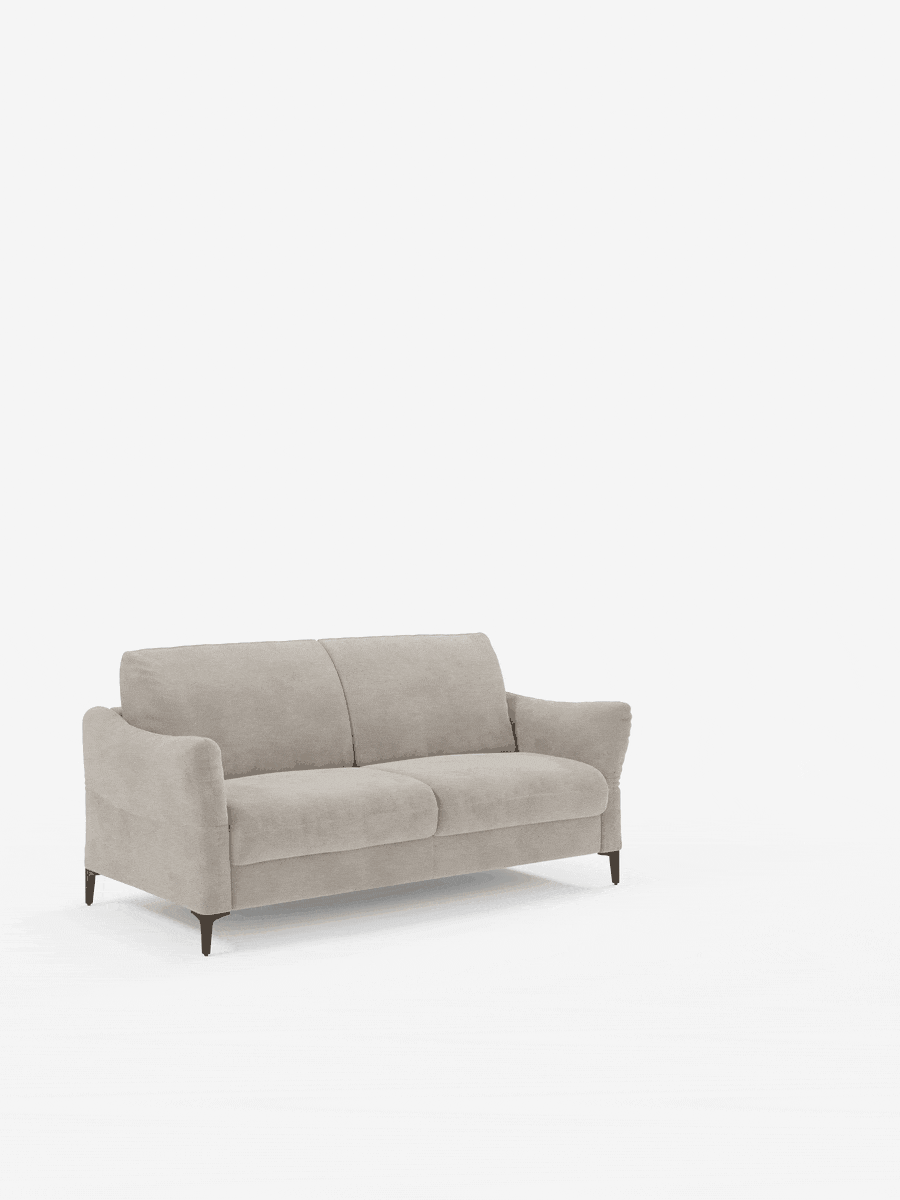 Un divano letto Dalia a 2 posti di colore grigio chiaro di Divani.Store spicca su uno sfondo bianco, mettendo in risalto il suo design moderno e minimalista. Rivestito in tessuto vellutino T30 di facile pulizia, questo divano letto presenta gambe nere sottili e affusolate, seduta e schienale imbottiti e morbidi, e braccioli dalle linee dolcemente arrotondate. Questo comodo divano letto offre comfort senza rinunciare allo stile in un ambiente essenziale.