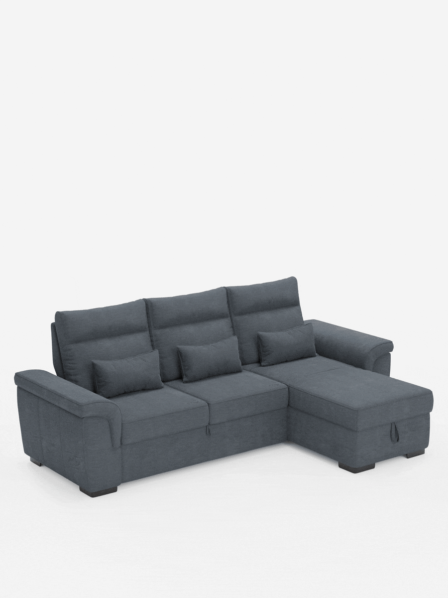 Un divano letto angolare Ischia color grigio antracite con chaise longue a destra, tre cuscini dello schienale con cuscini lombari e ampi braccioli, su uno sfondo bianco a tinta unita.
