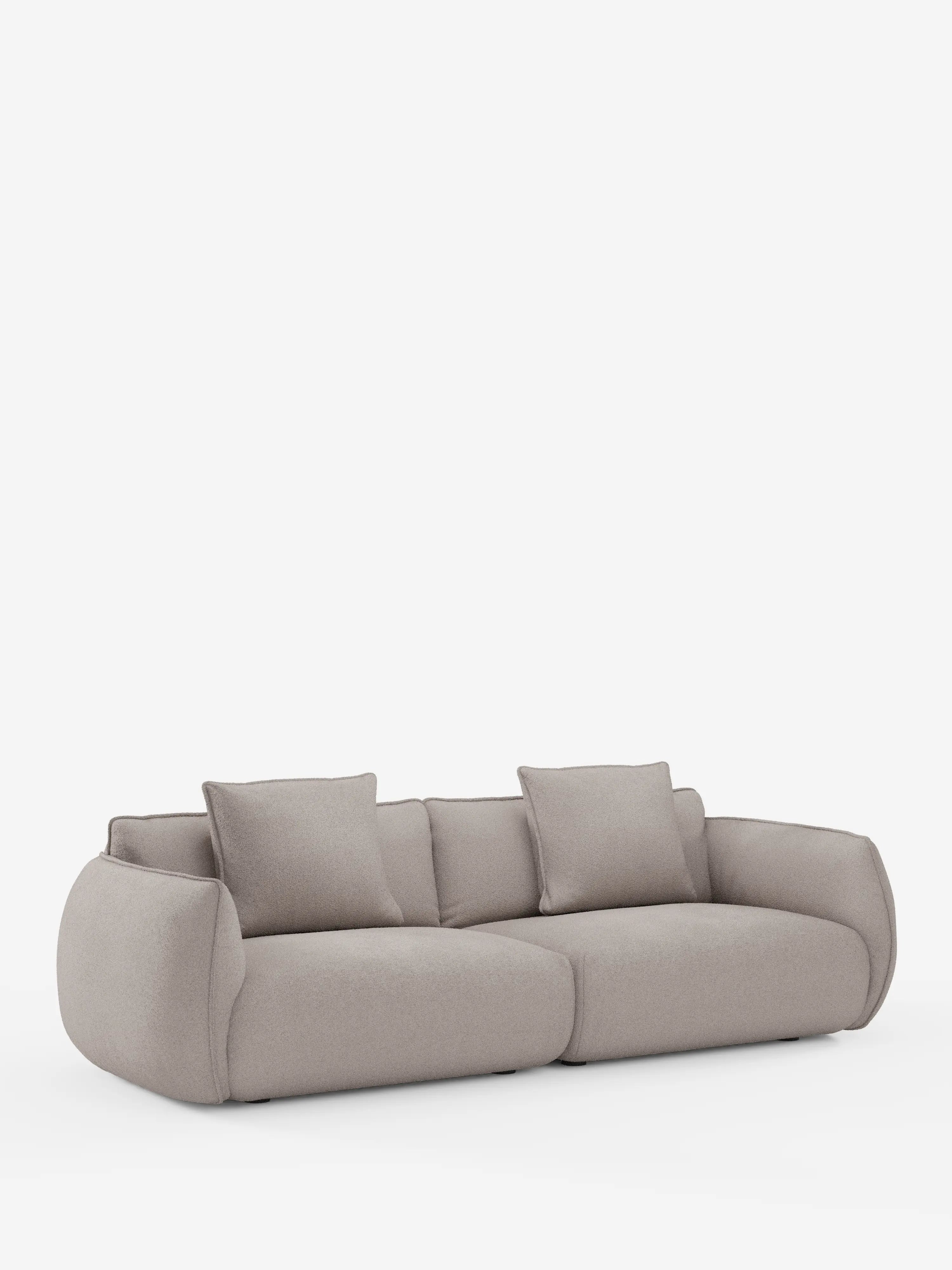 Un divano modulare e componibile Nimbus a 3 posti, in un moderno beige chiaro, di Divani.Store, lungo 250 cm e rivestito in tessuto sfoderabile effetto cotone antimacchia (t33). Questo divano presenta braccioli arrotondati e morbidi e uno schienale basso con due ampi cuscini di seduta e due cuscini schienali quadrati in tessuto coordinato. Presentato su uno sfondo bianco senza gambe a vista.