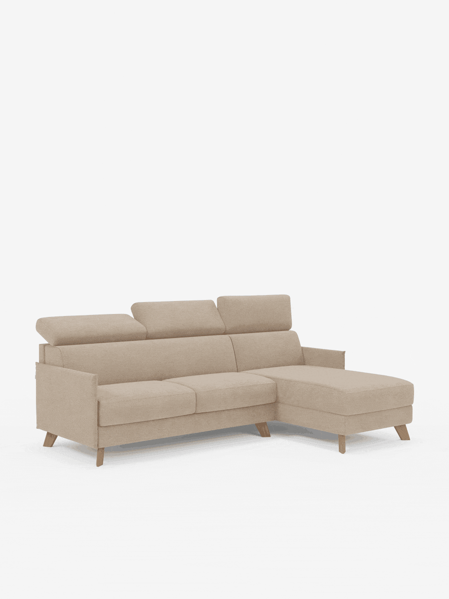 Il divano letto matrimoniale angolare Sole con penisola contenitore e poggiatesta reclinabili di Divani.Store è rivestito in tessuto beige T23 antimacchia. Dotato di tre cuscini di seduta, tre poggiatesta regolabili e una chaise longue orientata a destra, questo divano di ispirazione scandinava presenta gambe angolari in legno e linee pulite e moderne. Su uno sfondo bianco a tinta unita, questo elegante divano letto diventa il punto focale della stanza.