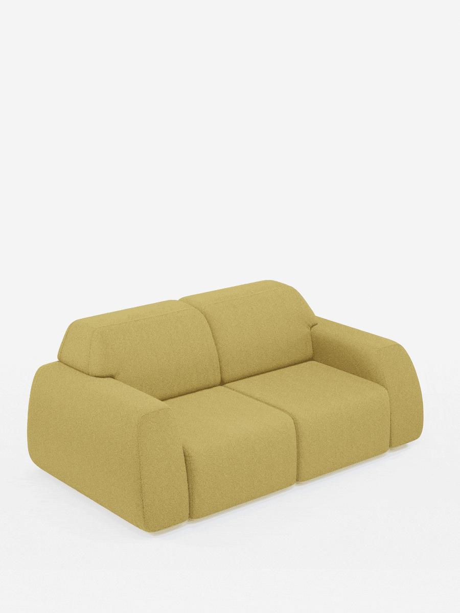 Su uno sfondo bianco a tinta unita è raffigurato un divano modulare giallo senape con bordi arrotondati e cuscini spessi. Questo divano moderno è a due posti, caratterizzato da braccioli bassi e da un design morbido e contemporaneo.