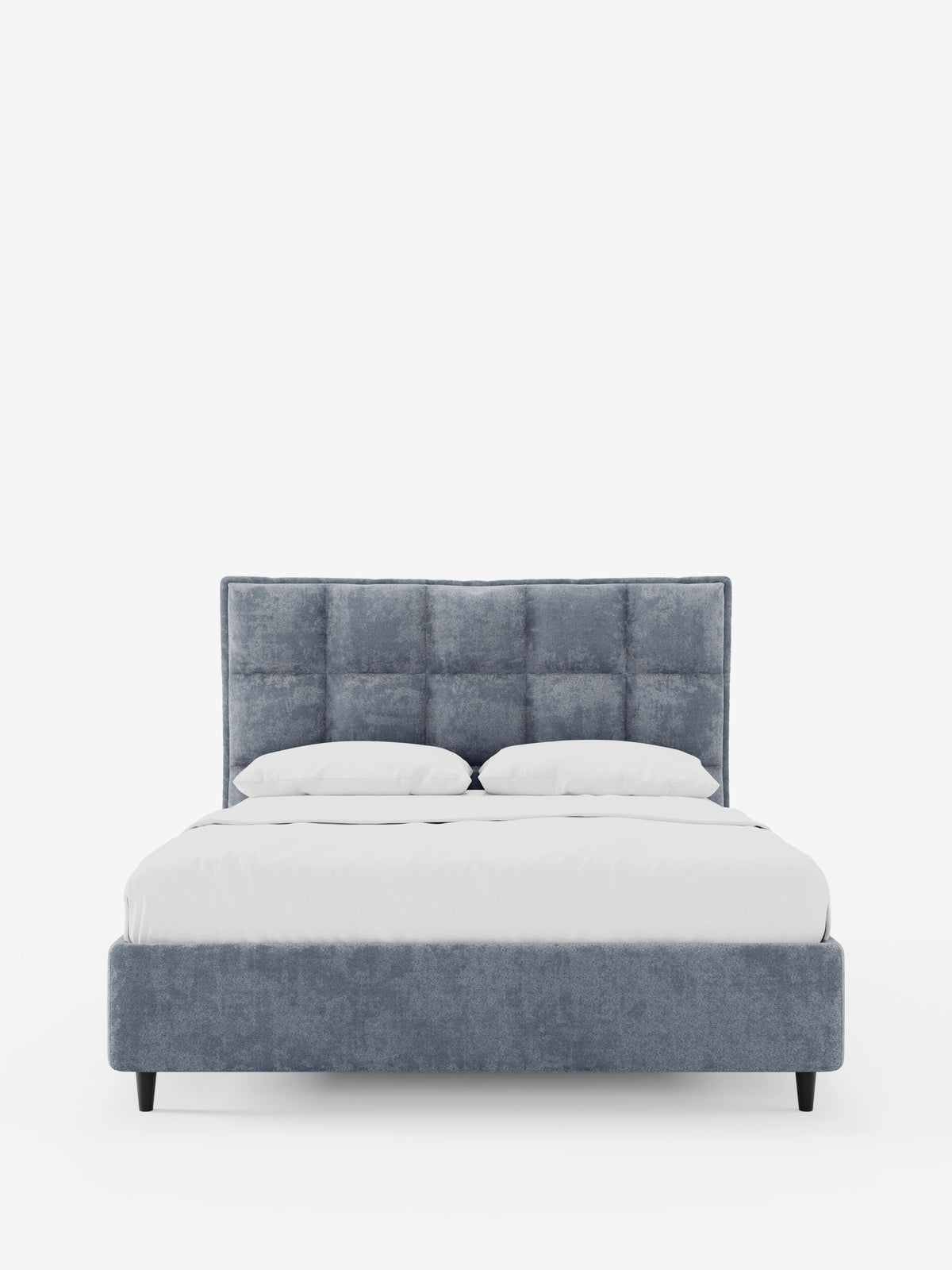 AURO, letto imbottito con contenitore e testiera alta capitonné in ciniglia Oeko-Tex®, caratterizzato da una testiera in tessuto blu-grigio capitonné, due cuscini bianchi e gambe affusolate scure su uno sfondo bianco a tinta unita.