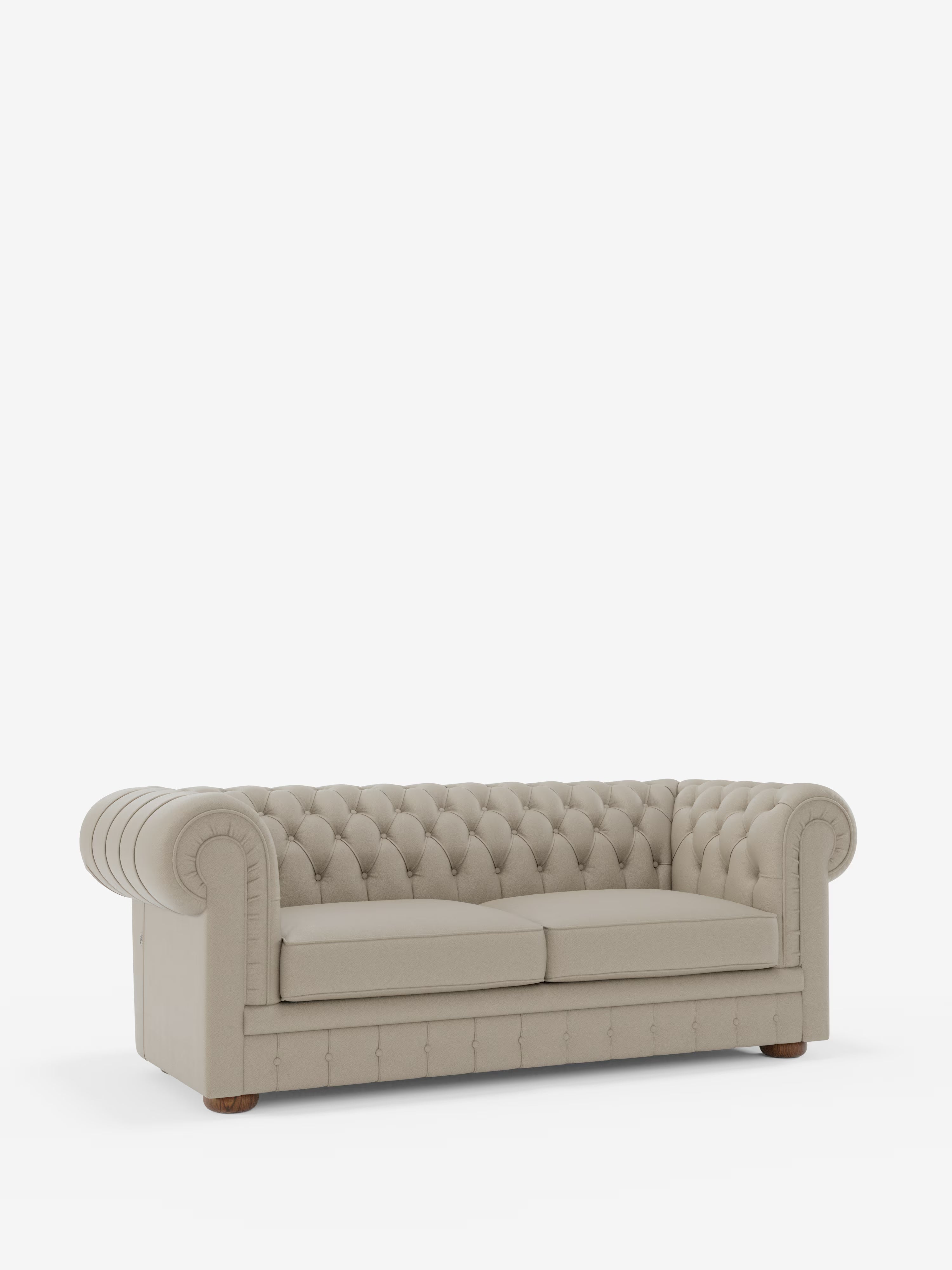 Un Chester beige – Divano Chesterfield in vera pelle spessorata a 2 e 3 posti di Divani.Store, caratterizzato da un lussuoso rivestimento in pelle trapuntata, braccioli arrotondati, profondi dettagli a bottoni e due cuscini di seduta. Questo elegante divano artigianale Made in Italy è realizzato in vera pelle di alta qualità con gambe corte e arrotondate in legno ed è presentato su uno sfondo bianco a tinta unita.