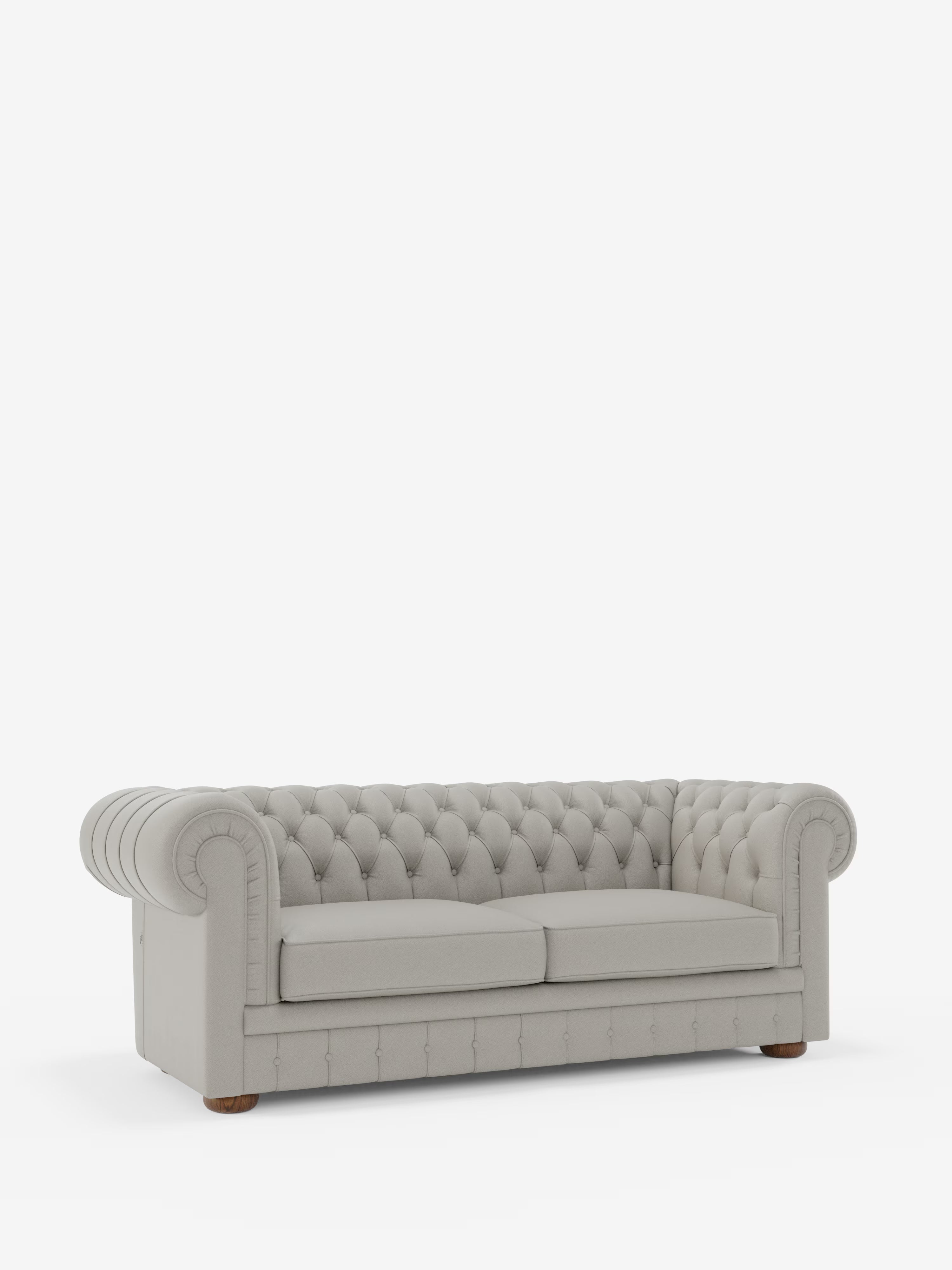 Un divano Chesterfield grigio chiaro – Divano Chesterfield in vera pelle spessorata a 2 e 3 posti di Divani.Store, caratterizzato da classica trapuntatura, braccioli arrotondati, imbottitura profonda e piedini in legno, è ripreso su uno sfondo bianco a tinta unita. Questo elegante divano presenta due cuscini di seduta e caratteristici dettagli a bottoni sullo schienale e sui braccioli.