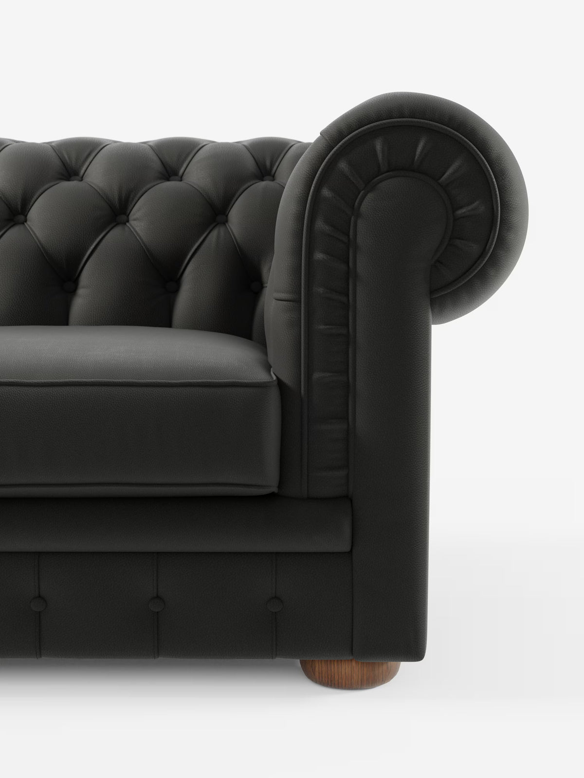 Primo piano del lato sinistro del divano Chester 4 Posti 3 sedute in Vera Pelle – Chesterfield Capitonné Artigianale di Divani.Store, caratterizzato da rivestimento in pelle nera trapuntata con bracciolo arrotondato, dettagli a bottoni, cuscino di seduta liscio e gamba in legno a vista, il tutto su uno sfondo bianco a tinta unita. Questo raffinato pezzo mette in risalto la lavorazione artigianale e la vera pelle, conferendogli un fascino elegante e senza tempo.