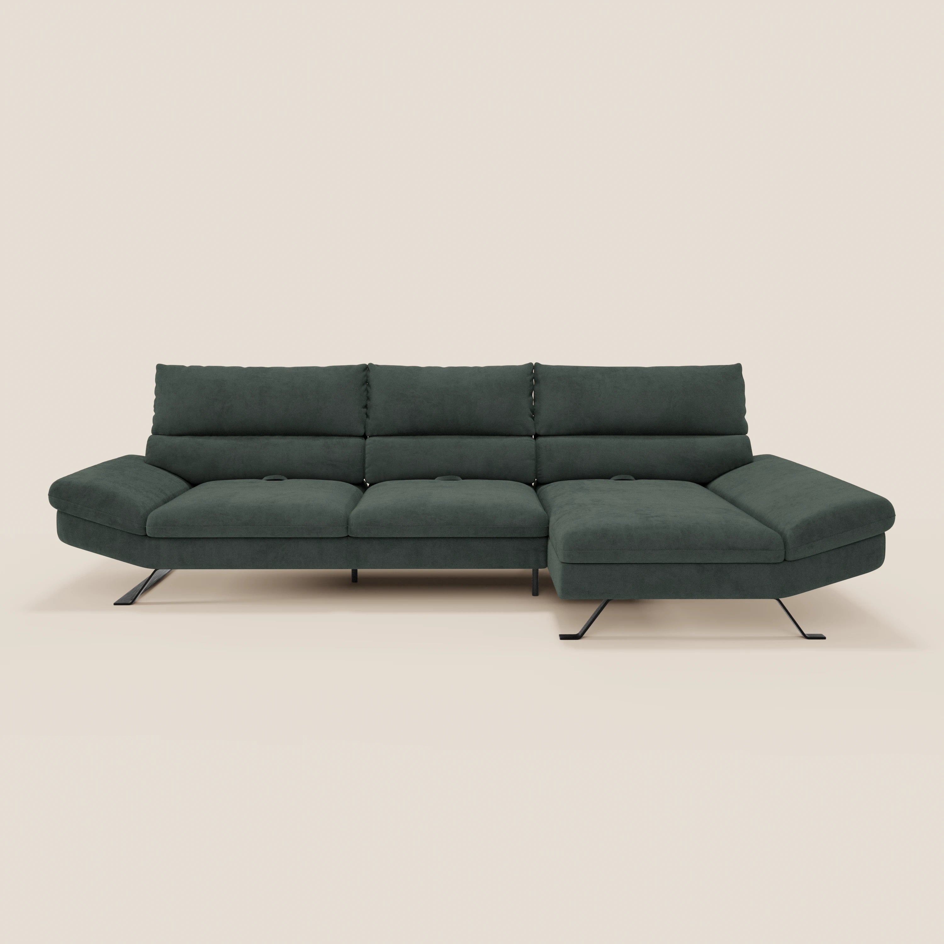 Il divano Eclipse angolare con penisola e schienali traslanti di Divani.Store è caratterizzato da tre cuscini di seduta e di schienale in verde scuro, con una chaise longue a destra e sottili gambe in metallo nero, su uno sfondo beige chiaro.
