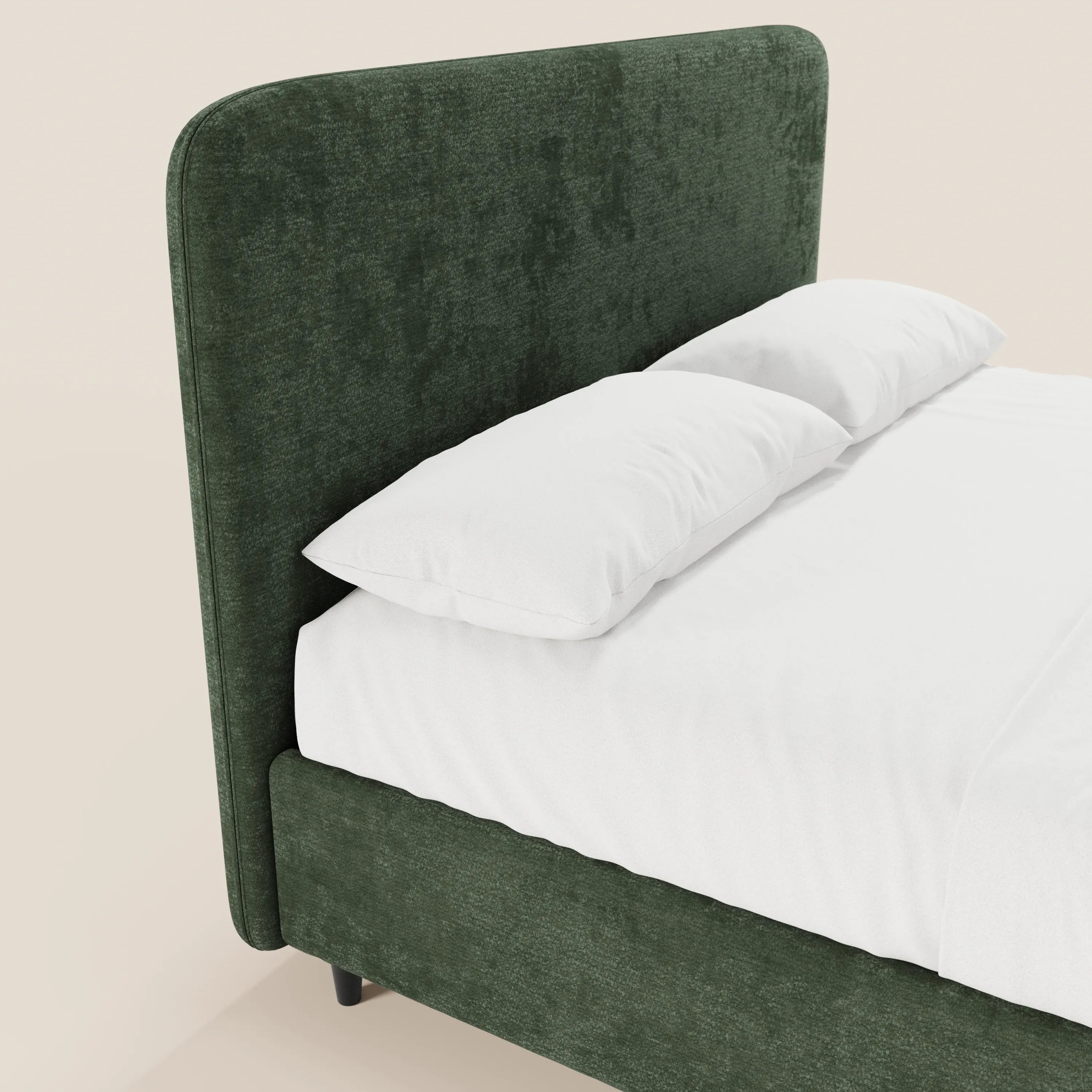 Il letto imbottito KAELOS minimal di Letti.store presenta una testiera alta e ricurva rivestita in ciniglia, gambe alte e un vano contenitore. Nella foto è raffigurato in verde scuro con biancheria da letto bianca, su uno sfondo beige chiaro.