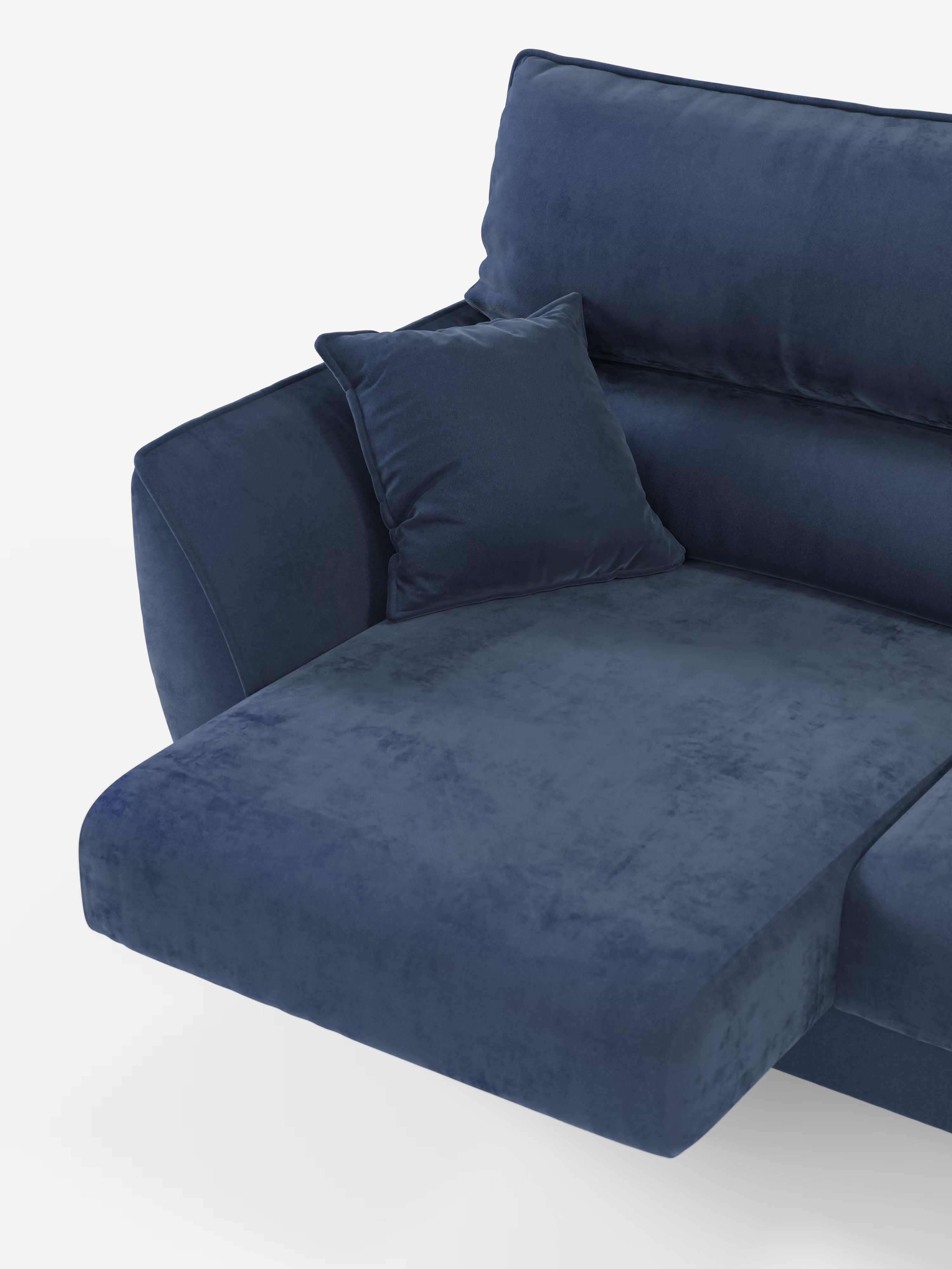 Un primo piano del divano Michelangelo 4 Posti di Divani.Store, dotato di tre sedute estensibili e poggiatesta reclinabili, rivestito in elegante velluto T30 blu scuro resistente alle macchie, mette in risalto la chaise longue sul lato sinistro, l’ampio bracciolo imbottito, lo schienale alto e un cuscino decorativo quadrato abbinato, il tutto su uno sfondo bianco a tinta unita.