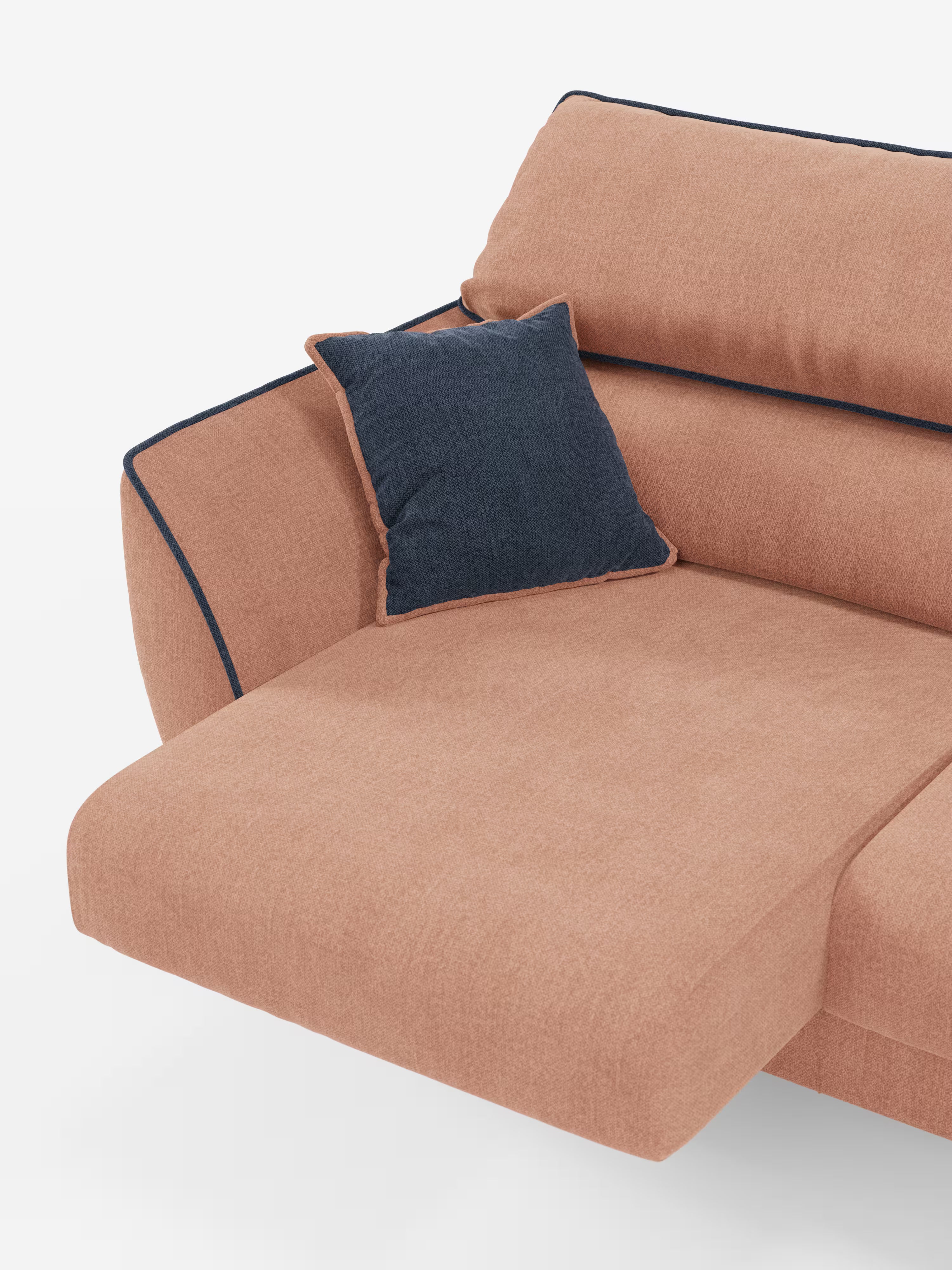 Il divano Michelangelo a 2 e 3 posti con sedute allungabili e poggiatesta reclinabili di Divani.Store è presentato in una versione bicolore pesca e blu scuro con sezione chaise longue. Il divano presenta una bordatura a contrasto in blu scuro lungo i bordi che conferisce un tocco moderno, ed è corredato da un unico cuscino quadrato blu scuro appoggiato sul bracciolo. Lo sfondo è bianco.