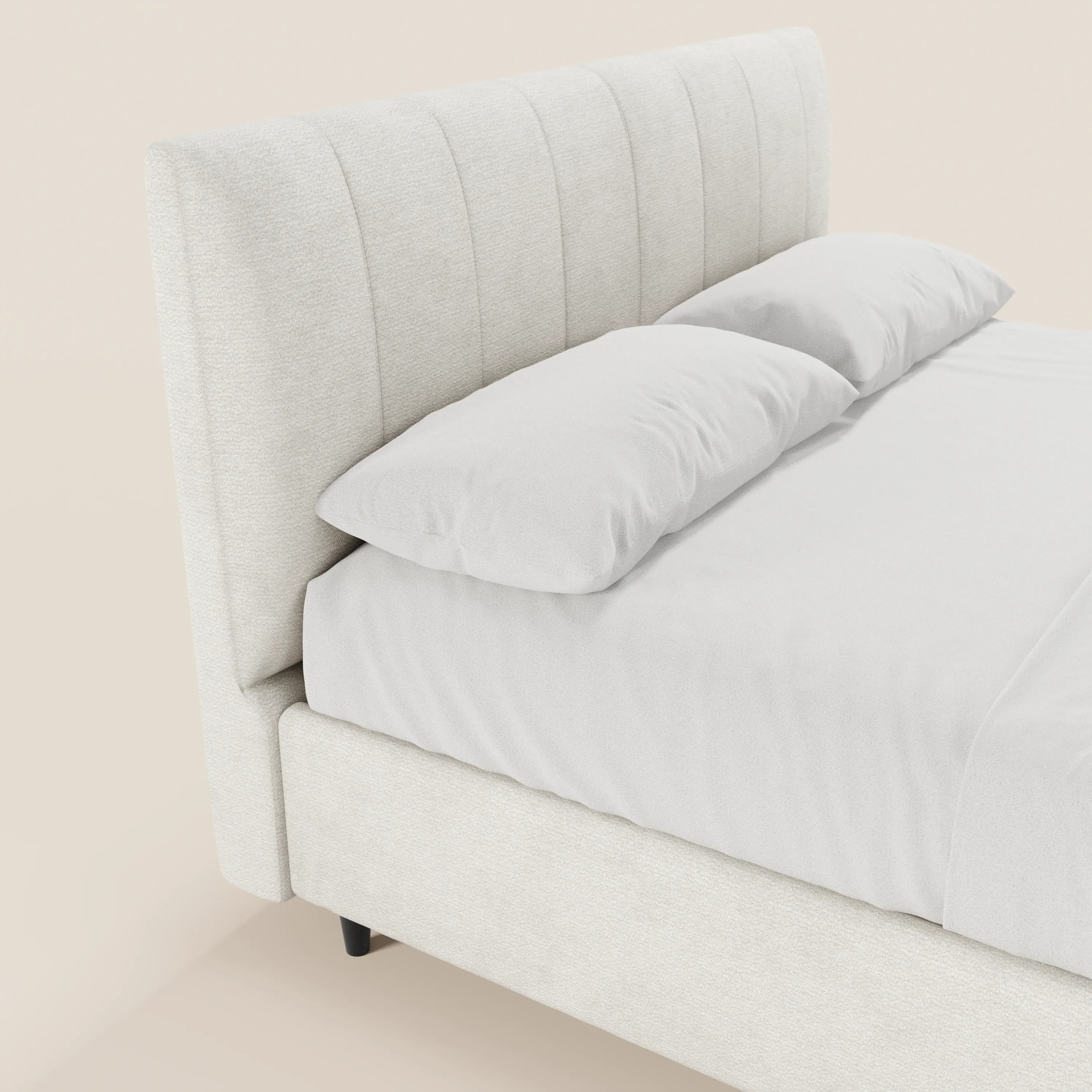 Un primo piano del letto imbottito con contenitore ONYX di Letti.store, caratterizzato da una testiera alta e verticale in tessuto beige chiaro certificato Oeko-Tex®. Il letto è rifatto con cura con lenzuola e cuscini bianchi, su uno sfondo chiaro.