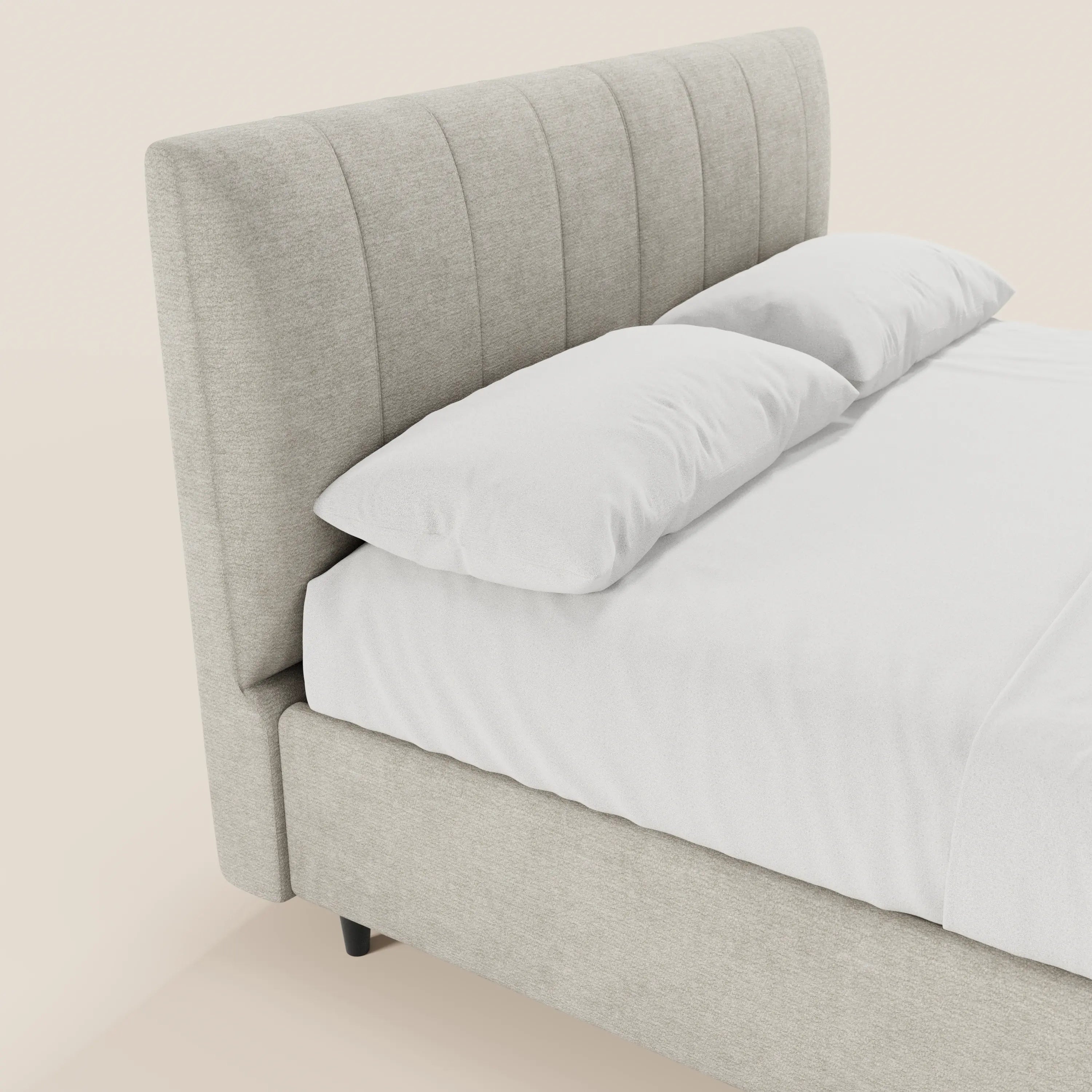 Il letto imbottito ONYX di Letti.store presenta una testiera alta, rivestita con pannelli verticali in tessuto grigio chiaro certificato Oeko-Tex®, e una base contenitore, abbinata a biancheria da letto bianca e due grandi cuscini su uno sfondo chiaro.