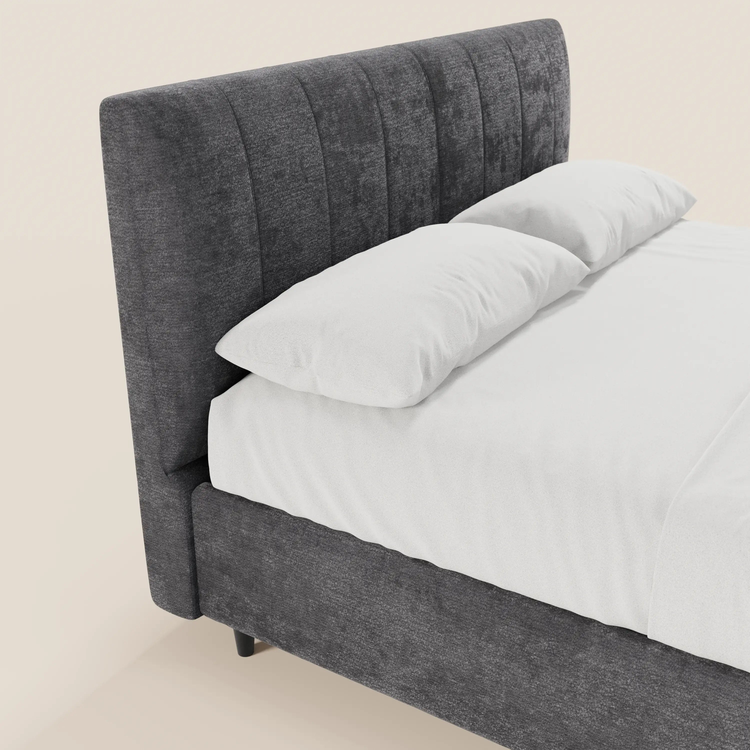 Un primo piano del letto imbottito con contenitore ONYX di Letti.store, caratterizzato da una testiera alta in tessuto grigio scuro certificato Oeko-Tex® con cuciture verticali, rifinito con cura con lenzuola e cuscini bianchi per un look pulito e moderno.