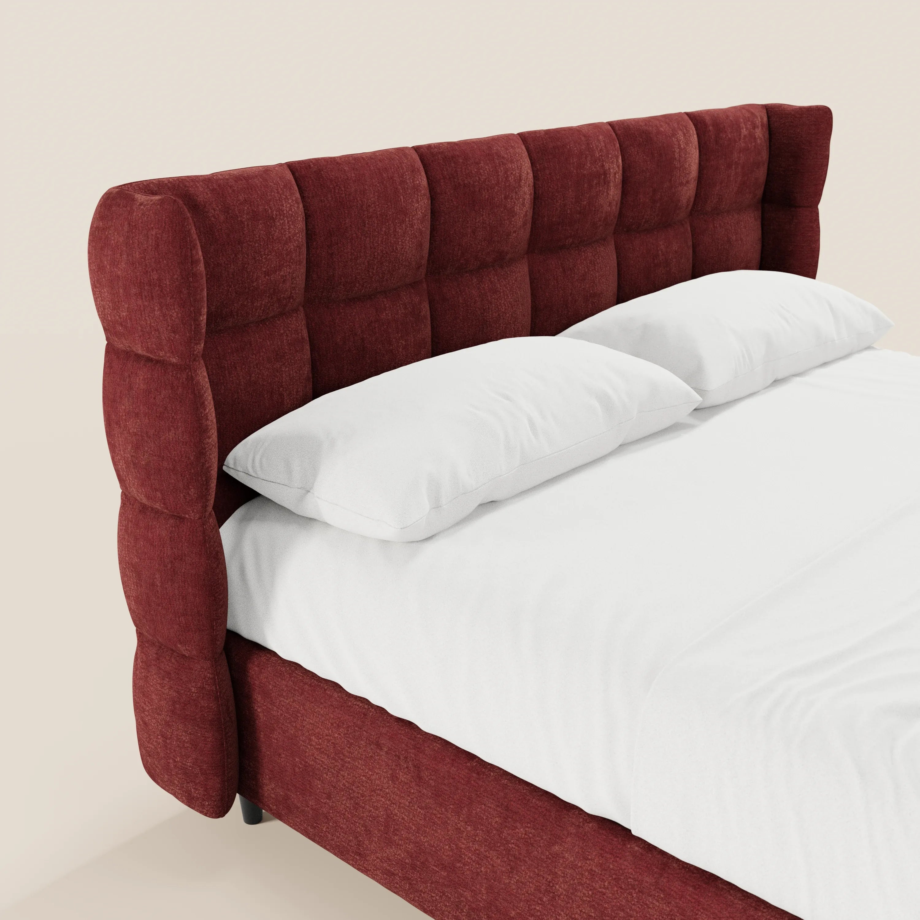 Il letto imbottito RAGNAR di Letti.store presenta una testiera avvolgente capitonné in elegante tessuto Oeko-Tex®, un rivestimento in morbido rosso intenso, biancheria da letto di un bianco candido e due cuscini su uno sfondo beige. Nel’immagine è visibile solo una parte del letto.