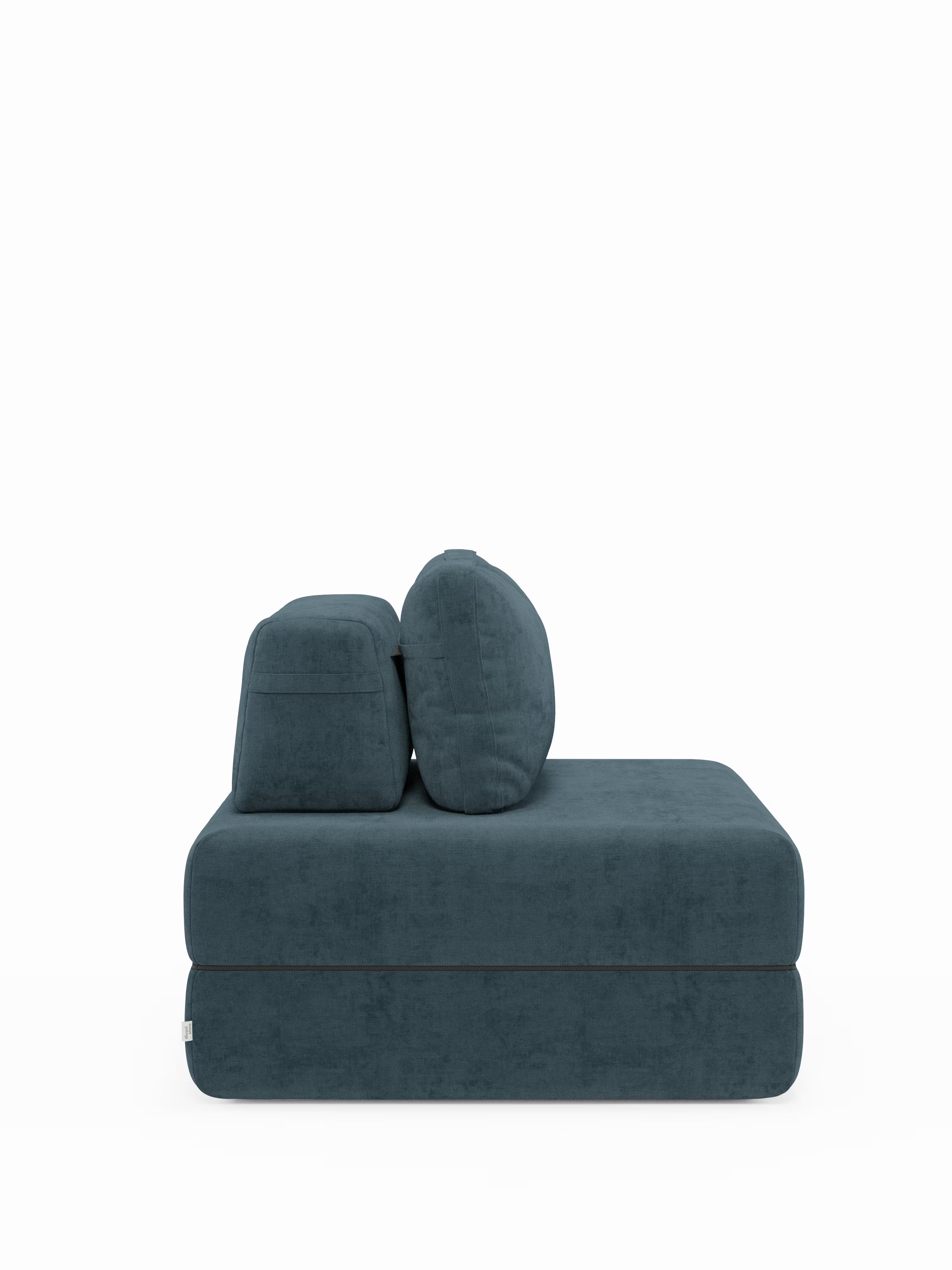Una vista laterale mostra la poltrona letto Rift con materasso alto 22 cm e memory foam di Divani.Store, rivestita in tessuto smacchiabile T31. Questa moderna poltrona letto si caratterizza per la tonalità verde acqua scuro, le sedute imbottite e spesse e gli schienali orientabili dai bordi arrotondati. Il rivestimento morbido e soffice e il design minimalista e contemporaneo ne sottolineano la funzione trasformabile in poltrona letto. Il prodotto è esposto su uno sfondo bianco a tinta unita.