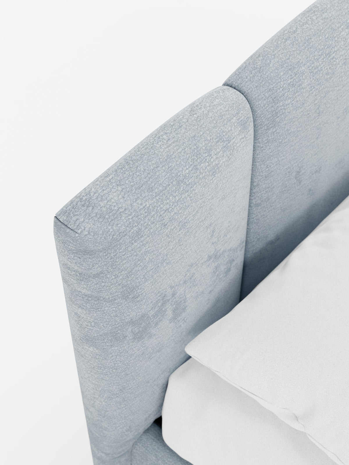 Primo piano del letto imbottito ARKAM con contenitore e testiera a cuciture verticali di Letti.store, caratterizzato da una testiera azzurra con cuciture verticali realizzata in tessuto certificato Oeko-Tex®. Il letto è abbinato a un cuscino beige chiaro o bianco sporco e a una biancheria da letto coordinata, creando un’estetica shabby chic sobria e minimalista. La scena è illuminata da una luce intensa su uno sfondo pulito.