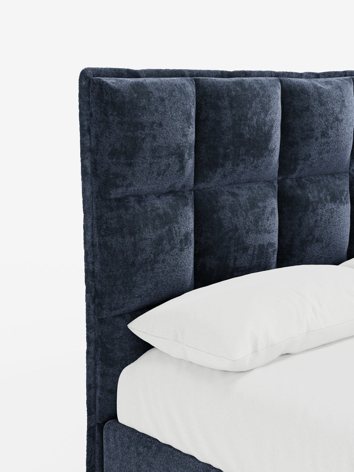 Primo piano del letto imbottito AURO con contenitore e testiera capitonné alta in ciniglia Oeko-Tex® di Letti.store, caratterizzato da una testiera capitonné blu scuro con pannelli quadrati e un raffinato effetto capitonné. Un cuscino e un materasso bianchi sono parzialmente visibili su uno sfondo bianco a tinta unita, mettendo in risalto la morbida consistenza e il design contemporaneo di questo elegante letto moderno per camere da letto.