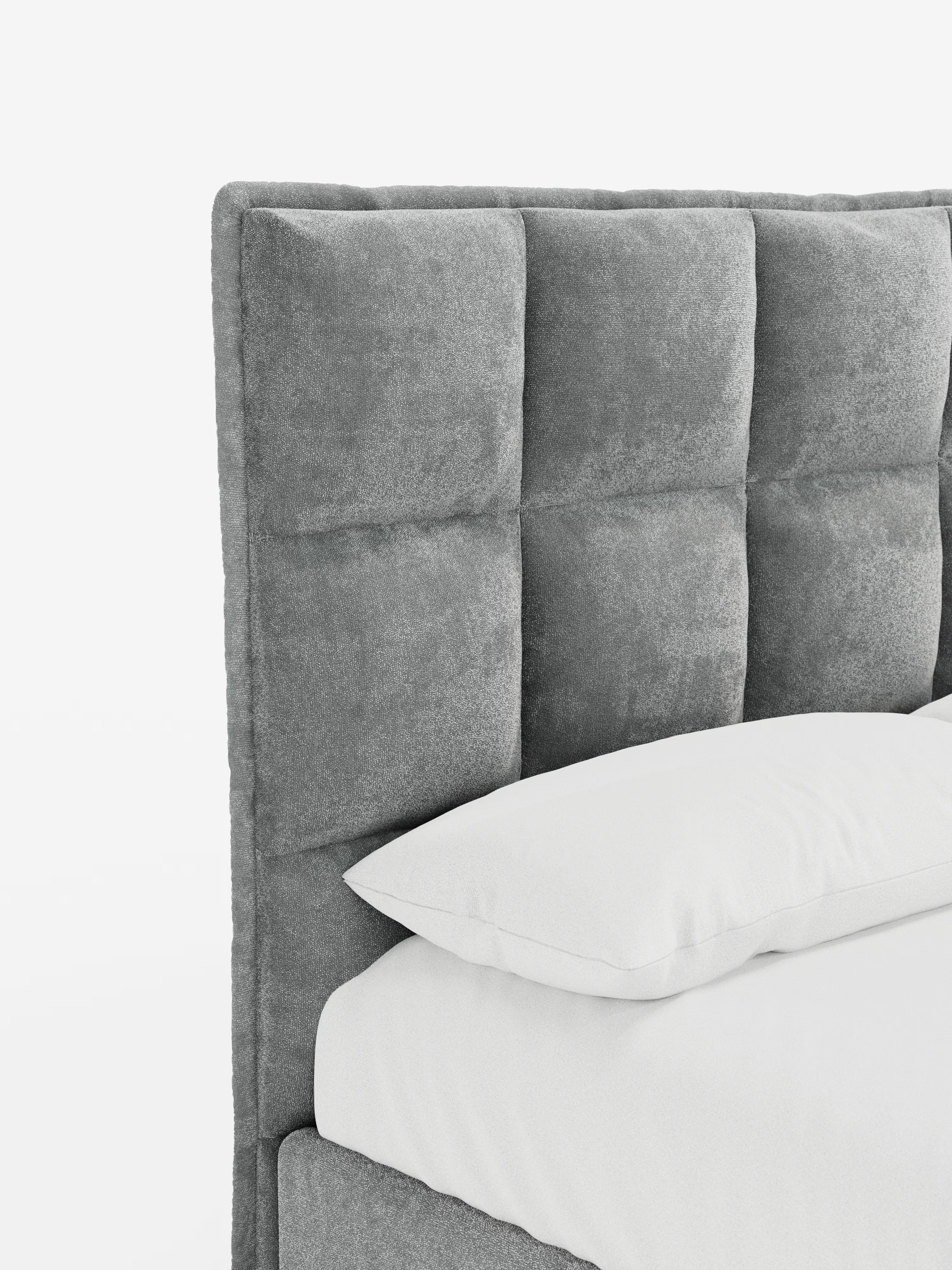 Primo piano del letto imbottito AURO di Letti.store, caratterizzato da una testiera alta e imbottita con un’elegante trapuntatura capitonné. Il rivestimento in tessuto ciniglia certificato Oeko-Tex® appare morbido e ricco di texture. Si intravedono parzialmente un cuscino e un materasso bianchi, che mettono in risalto le linee pulite e i toni neutri del letto. Lo sfondo bianco a tinta unita sottolinea il design moderno e minimalista.