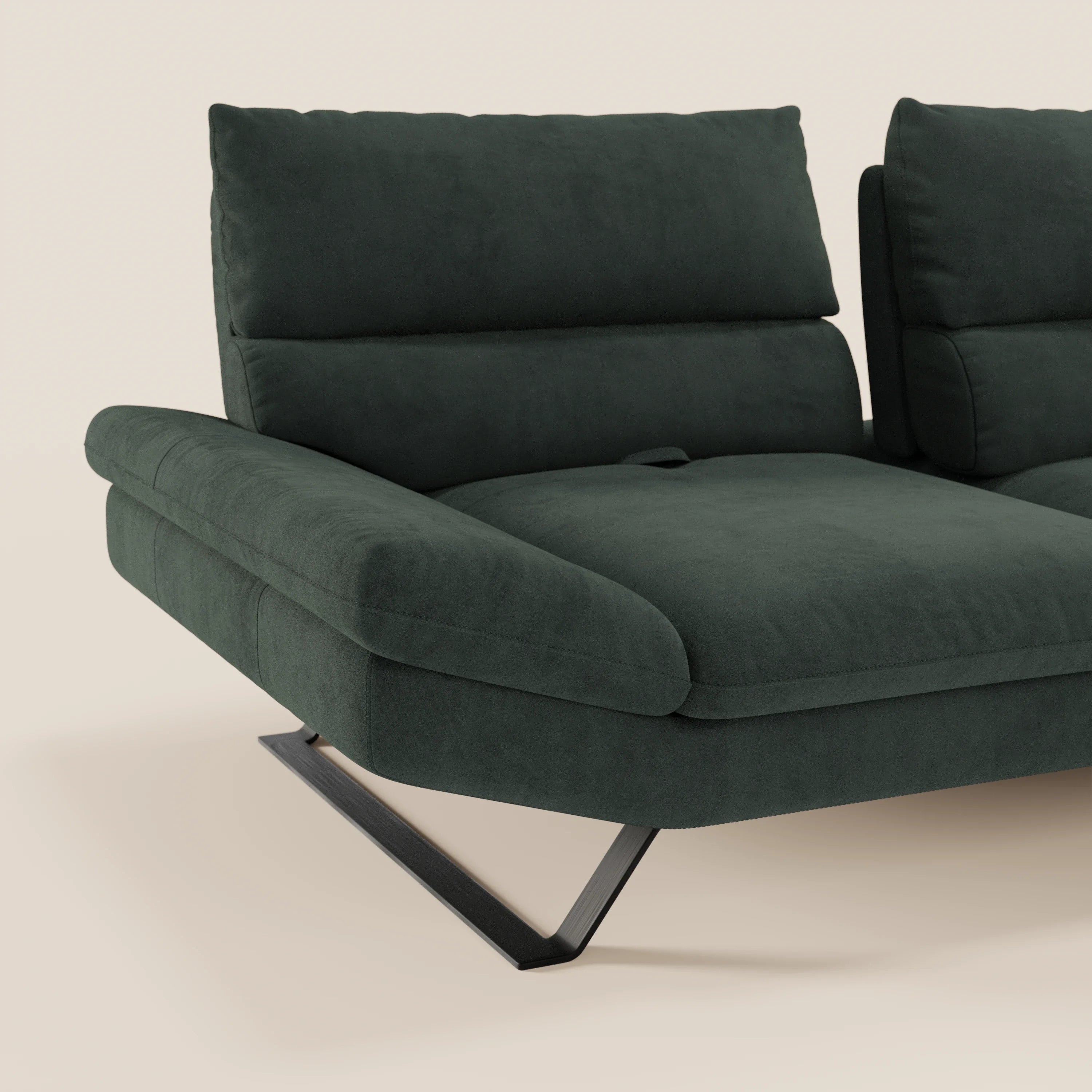 Il Divano Eclipse angolare con penisola e schienali traslanti di Divani.Store è caratterizzato da una microfibra verde scuro antimacchia, da cuscini in feltro, da ampi braccioli e da gambe a V in metallo nero. Solo una parte della chaise longue minimalista è mostrata su uno sfondo beige chiaro.