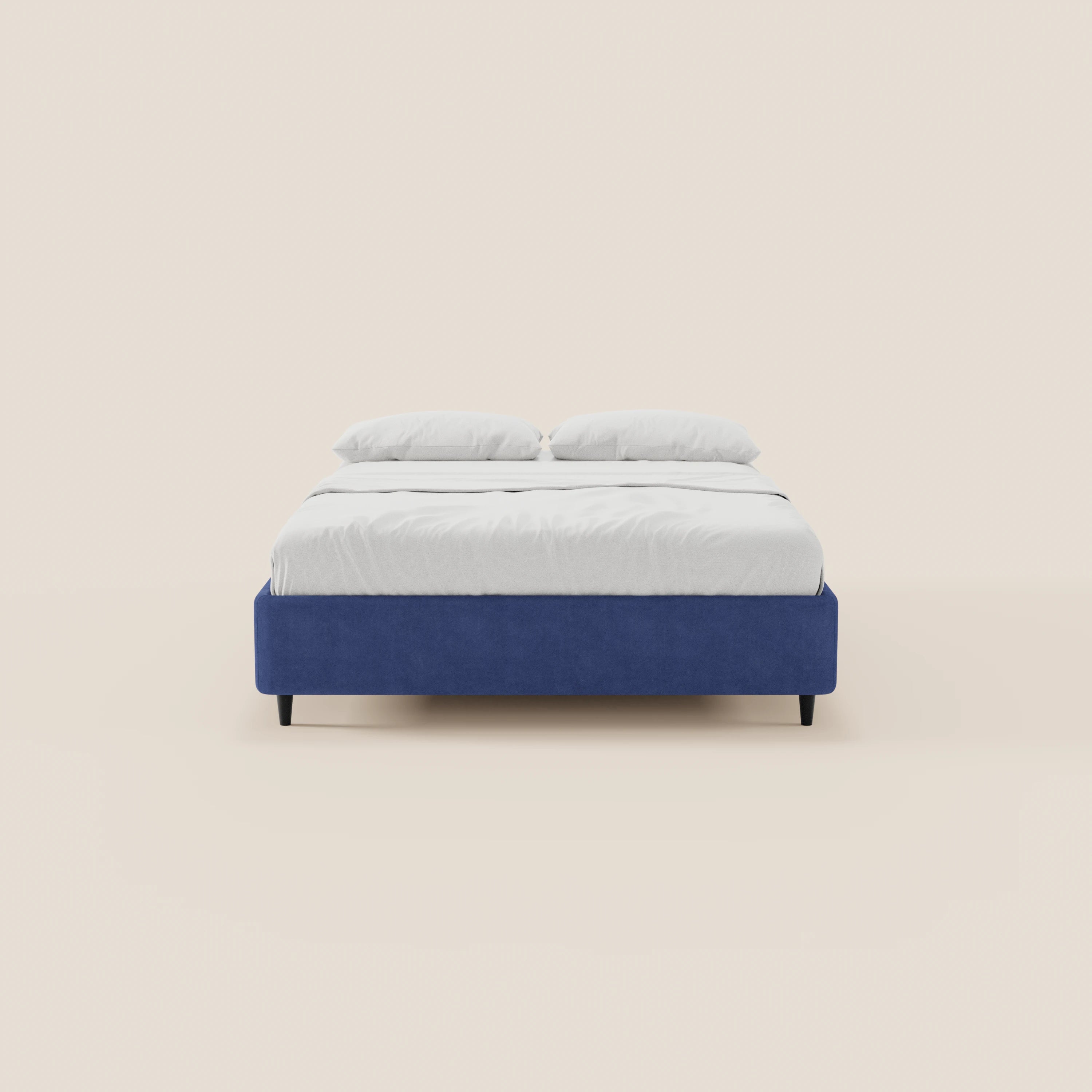 Il letto sommier imbottito con contenitore ERON di Letti.store presenta una struttura in tessuto blu impermeabile certificato Oeko-Tex, lenzuola bianche e due cuscini bianchi. Nell’immagine è raffigurato di fronte, con gambe corte scure e un design minimalista su uno sfondo beige chiaro.