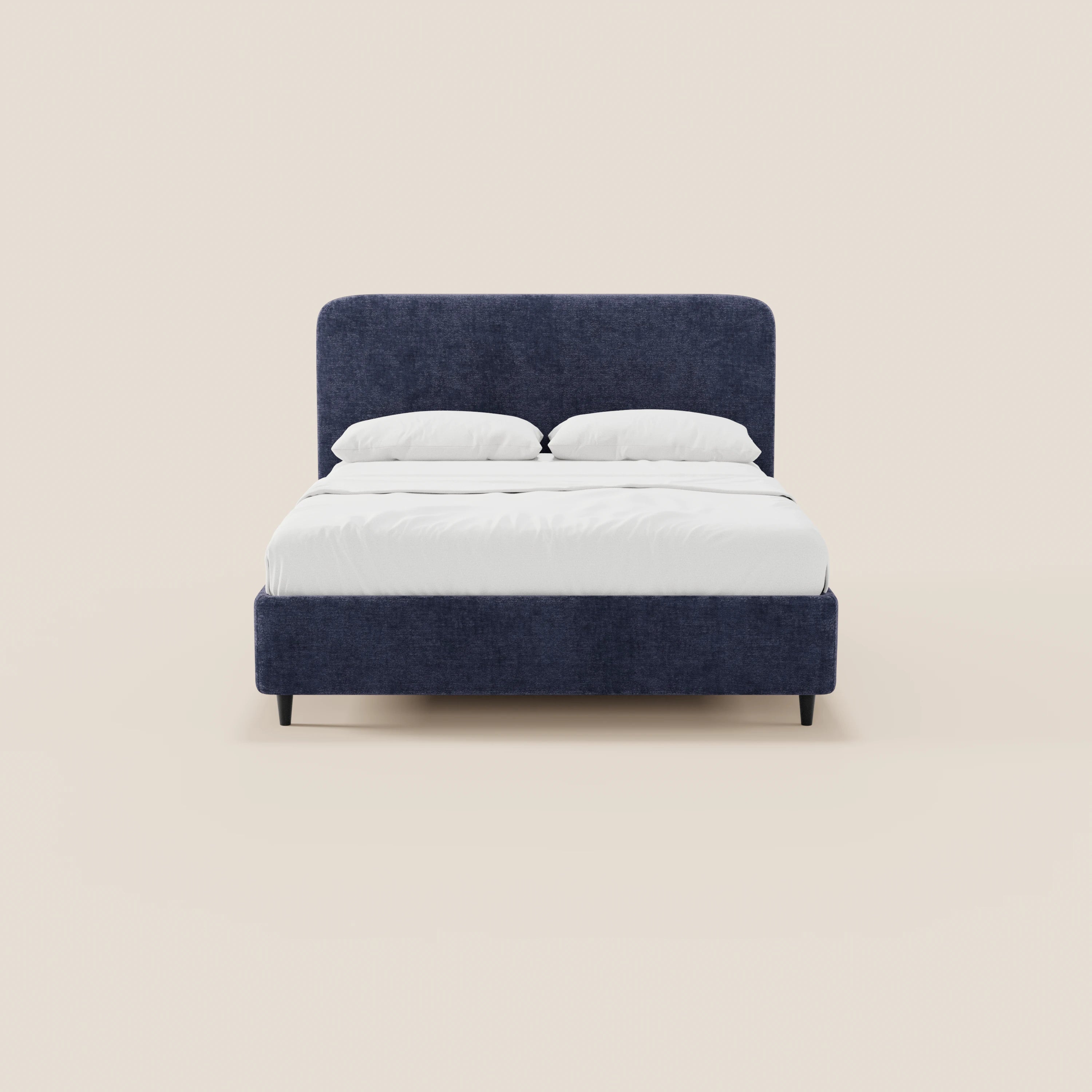 Il letto imbottito KAELOS minimal di Letti.store presenta una struttura rivestita in ciniglia blu scuro, gambe alte e una testiera arcuata. Abbellito da una biancheria da letto bianca, è posizionato al centro di uno sfondo beige chiaro a tinta unita.