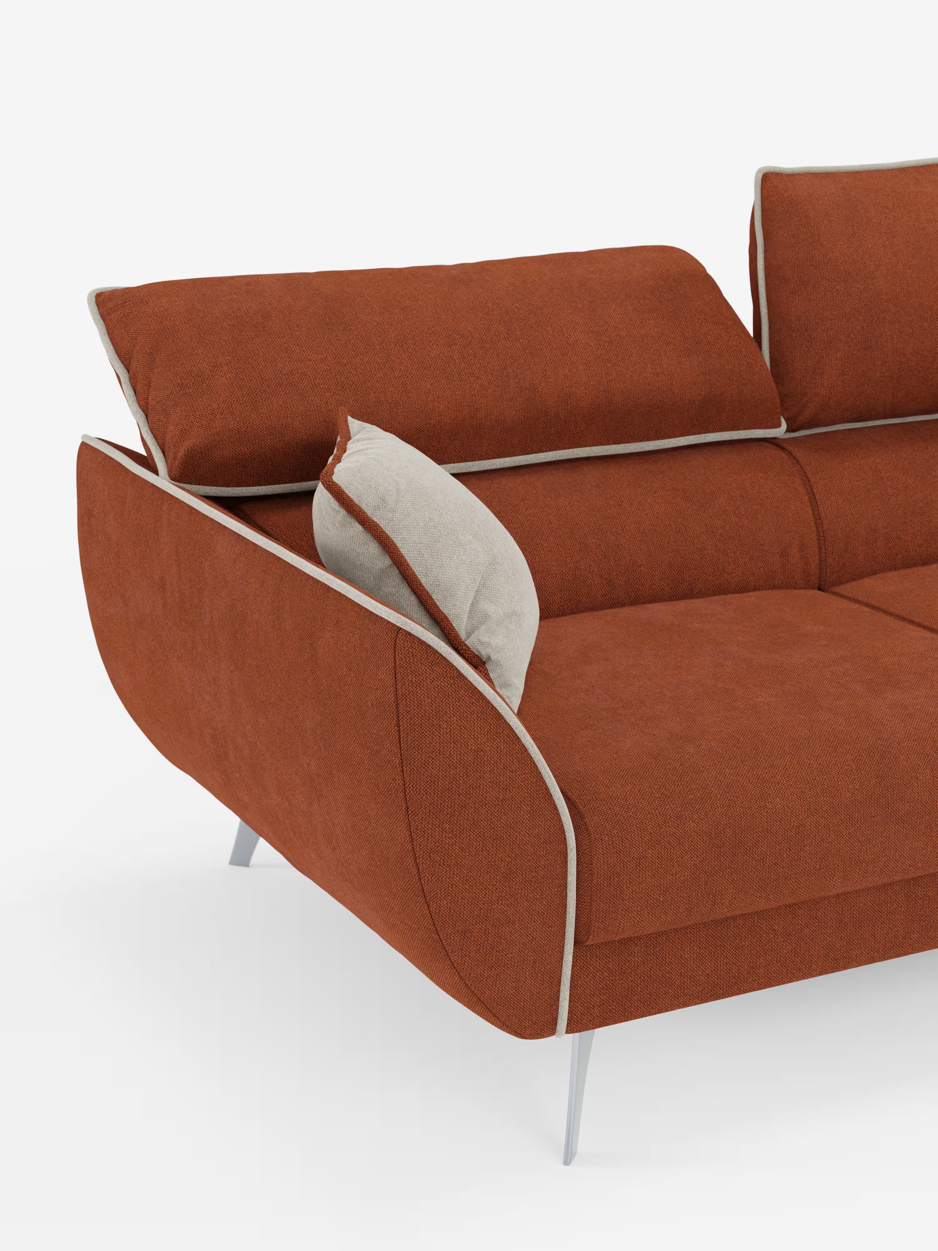 Un divano contemporaneo Michelangelo a 2 e 3 posti con sedute allungabili e poggiatesta reclinabili di Divani.Store, rivestito in tessuto bicolore arancione bruciato smacchiabile T23 con bordino bianco, caratterizzato da sottili gambe argentate e schienale regolabile. Un unico cuscino grigio chiaro è appoggiato al bracciolo. Lo sfondo è bianco a tinta unita.
