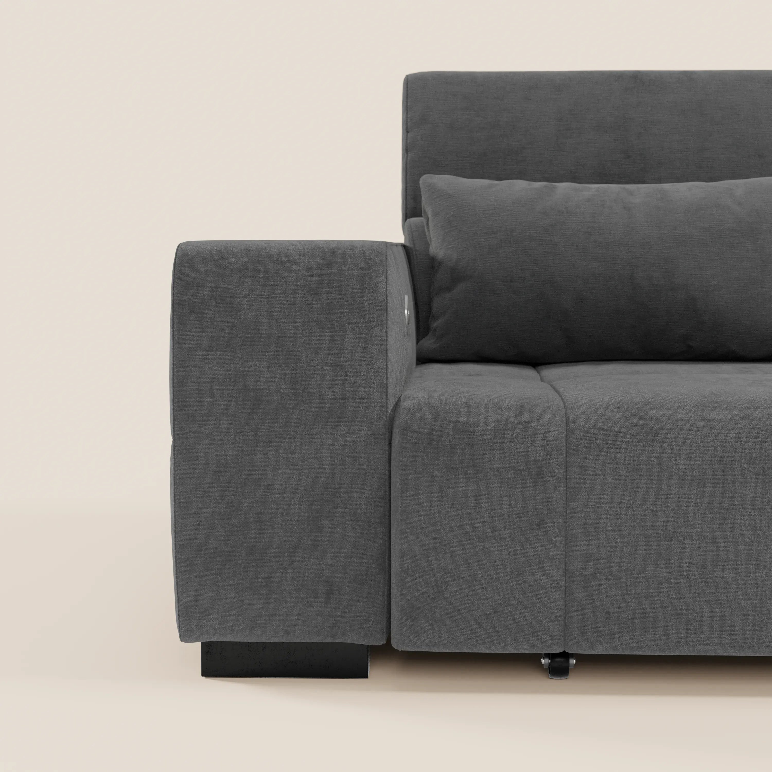 Un primo piano del Monarch Divano con Relax Elettrico di Divani.Store in tessuto T31 grigio scuro, che mette in evidenza il bracciolo sinistro, il cuscino della seduta e il cuscino abbinato su uno sfondo beige chiaro.