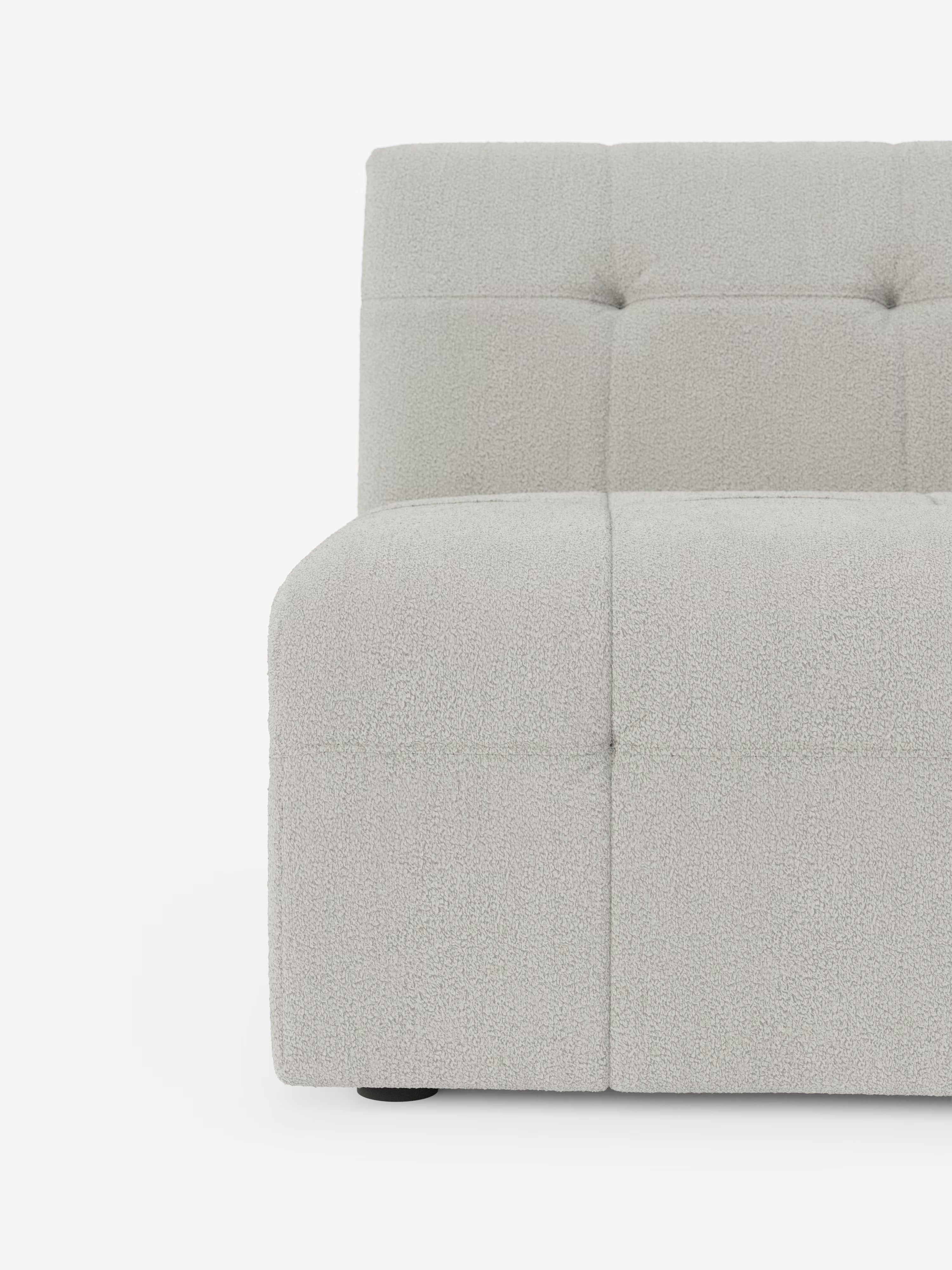 L'immagine mostra la metà sinistra della poltrona Mosaic modulo da 77 cm in bouclé capitonné e design in tessuto antimacchia T21 di Divani.Store. Questo pezzo italiano contemporaneo è rivestito in tessuto bouclé grigio chiaro antimacchia, con una caratteristica trapuntatura a quadrati sulla seduta e sullo schienale, che conferisce profondità e raffinatezza al suo design minimalista. La finitura testurizzata risalta sullo sfondo bianco a tinta unita, sottolineandone l’estetica moderna.