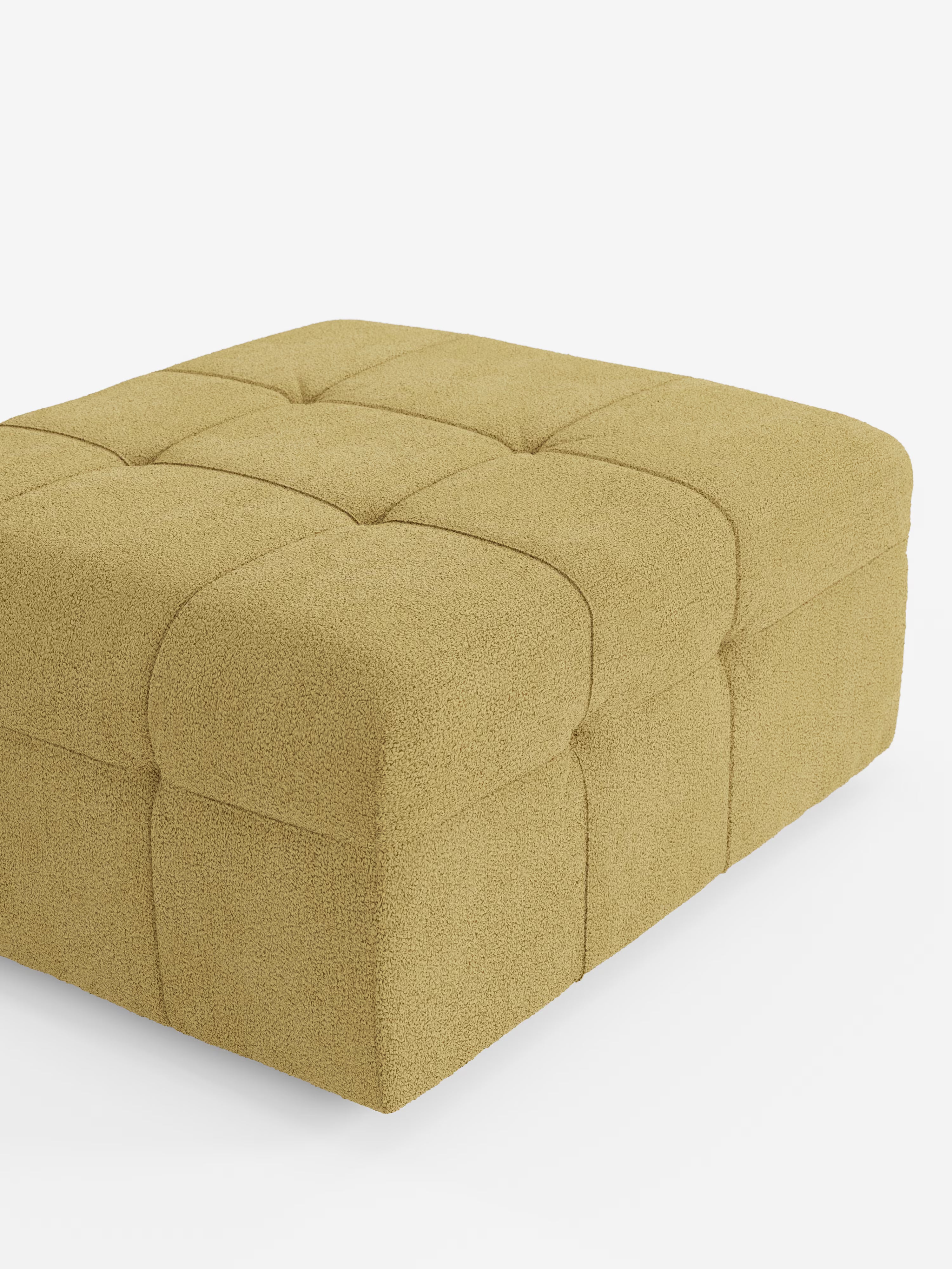 Un pouf quadrato “Mosaic” e modulo in bouclé di Divani.Store, dalle dimensioni di 96x77 cm, è rivestito in tessuto T21 antimacchia in una ricca tonalità di giallo senape. Il design capitonné presenta quadrati trapuntati sulla parte superiore e sui lati, che formano un classico motivo a griglia che ne esalta la lavorazione artigianale. Presentato su uno sfondo bianco a tinta unita, il pouf è ripreso in una vista laterale obliqua.