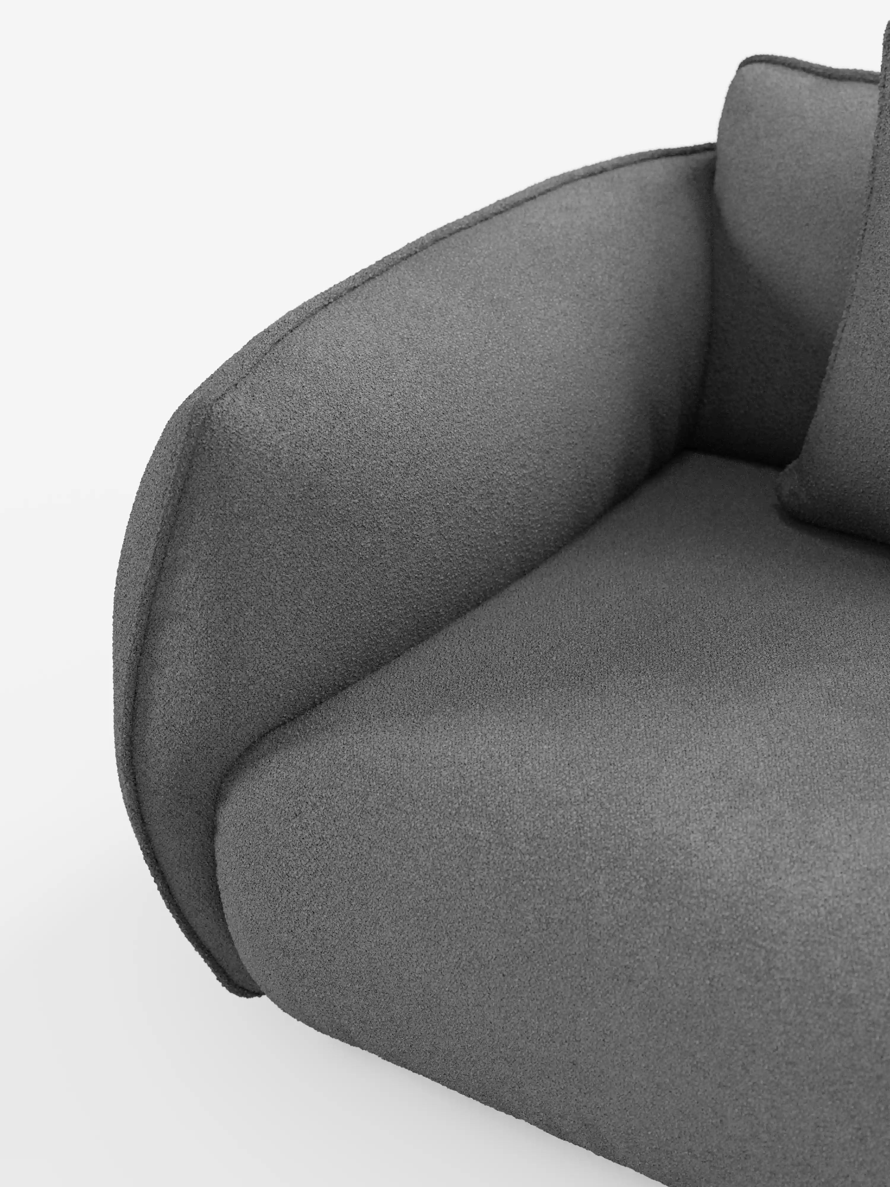 Primo piano del divano modulare e componibile a 3 posti Nimbus da 250 cm di Divani.Store, qui presentato in un moderno tessuto effetto cotone grigio scuro, resistente alle macchie (t33). L'immagine mette in risalto solo una parte del cuscino della seduta, del cuscino dello schienale e del bracciolo imbottito arrotondato a sinistra su uno sfondo bianco a tinta unita. Non sono visibili né le gambe né altri elementi d'arredo.