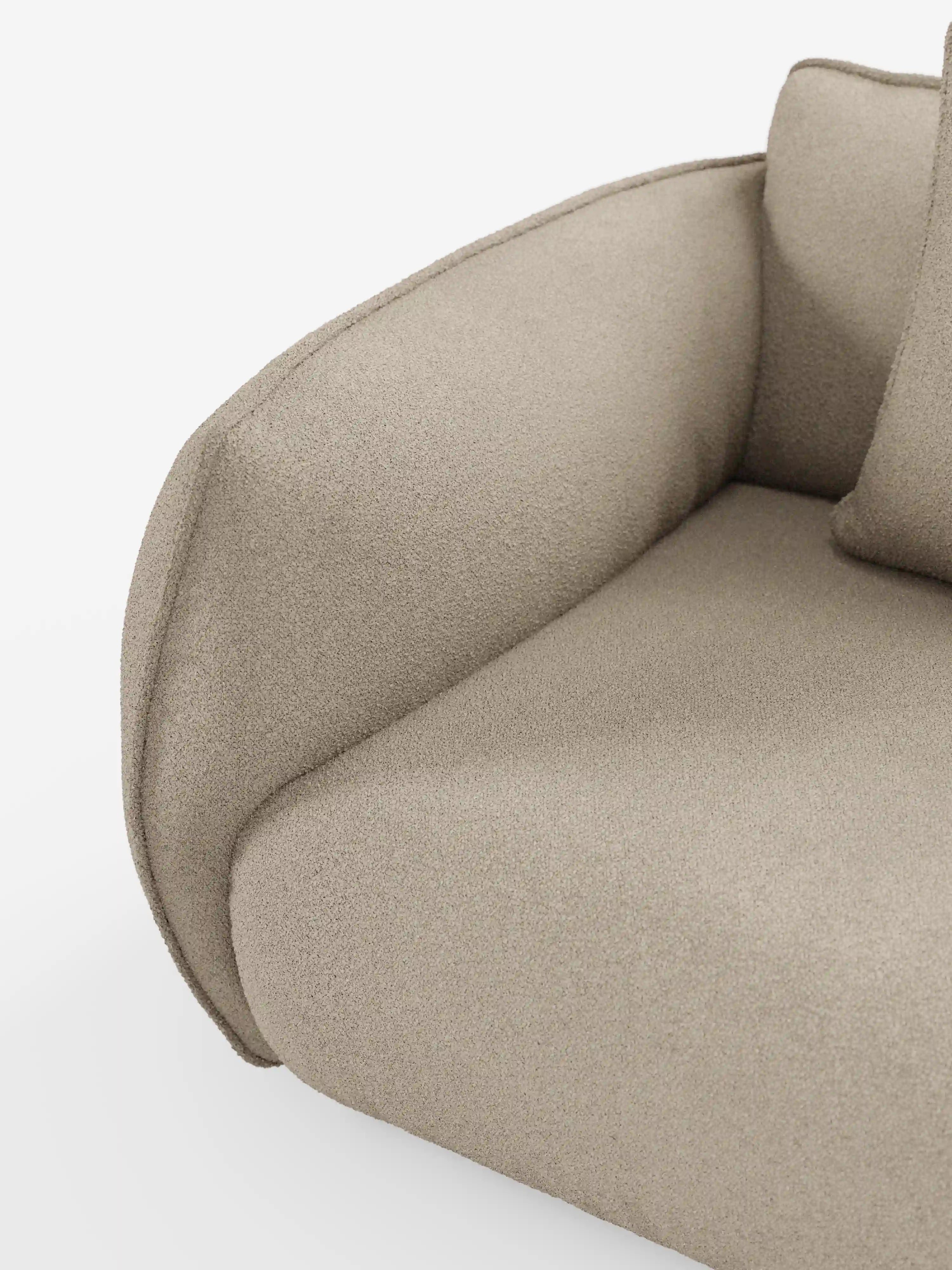 Primo piano del divano modulare e componibile a 3 posti Nimbus da 250 cm di Divani.Store, che mette in risalto il suo tessuto beige, testurizzato, smacchiabile, effetto cotone T33. L’immagine mette in risalto il bracciolo arrotondato e il cuscino di seduta del modulo angolare, con una parte dello schienale e un cuscino visibili. Sullo sfondo bianco a tinta unita, risaltano le linee morbide e il design moderno del divano.