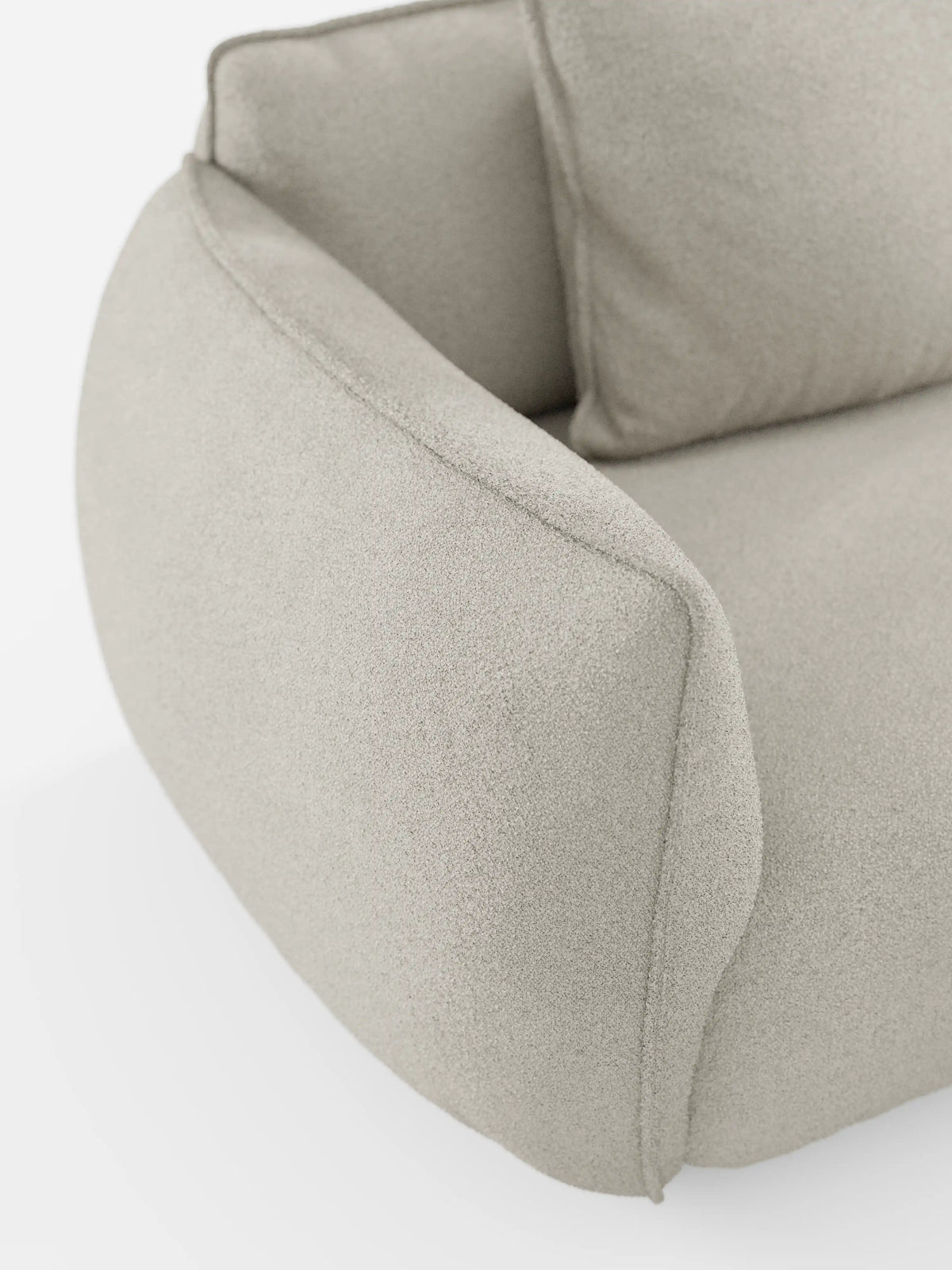 Primo piano del divano angolare con penisola componibile Nimbus di Divani.Store, rivestito in morbido tessuto T33 antimacchia con una trama effetto cotone. Il rivestimento beige chiaro presenta un aspetto delicato e strutturato, mentre il design è caratterizzato da bordi lisci e arrotondati che conferiscono al divano un’estetica accogliente e contemporanea. Lo sfondo bianco mette in risalto l’eleganza del complemento d’arredo.