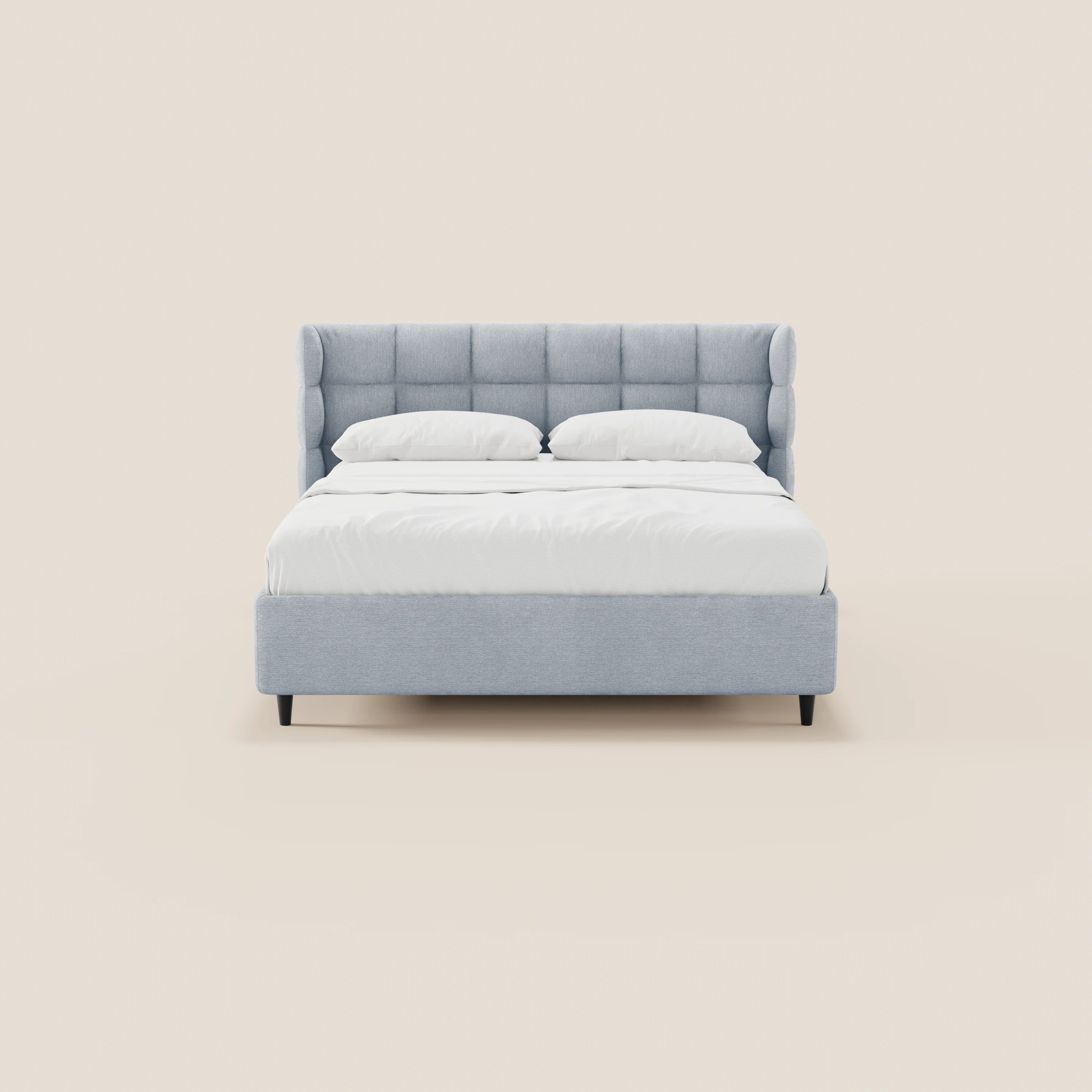 Il letto imbottito RAGNAR di Letti.store presenta una testiera capitonné grigia chiara e una struttura avvolgente. Nella foto è abbinato a lenzuola e cuscini bianchi e poggia su gambe in legno scuro, per un look minimalista. Tessuto certificato Oeko-Tex® e base contenitore inclusi.