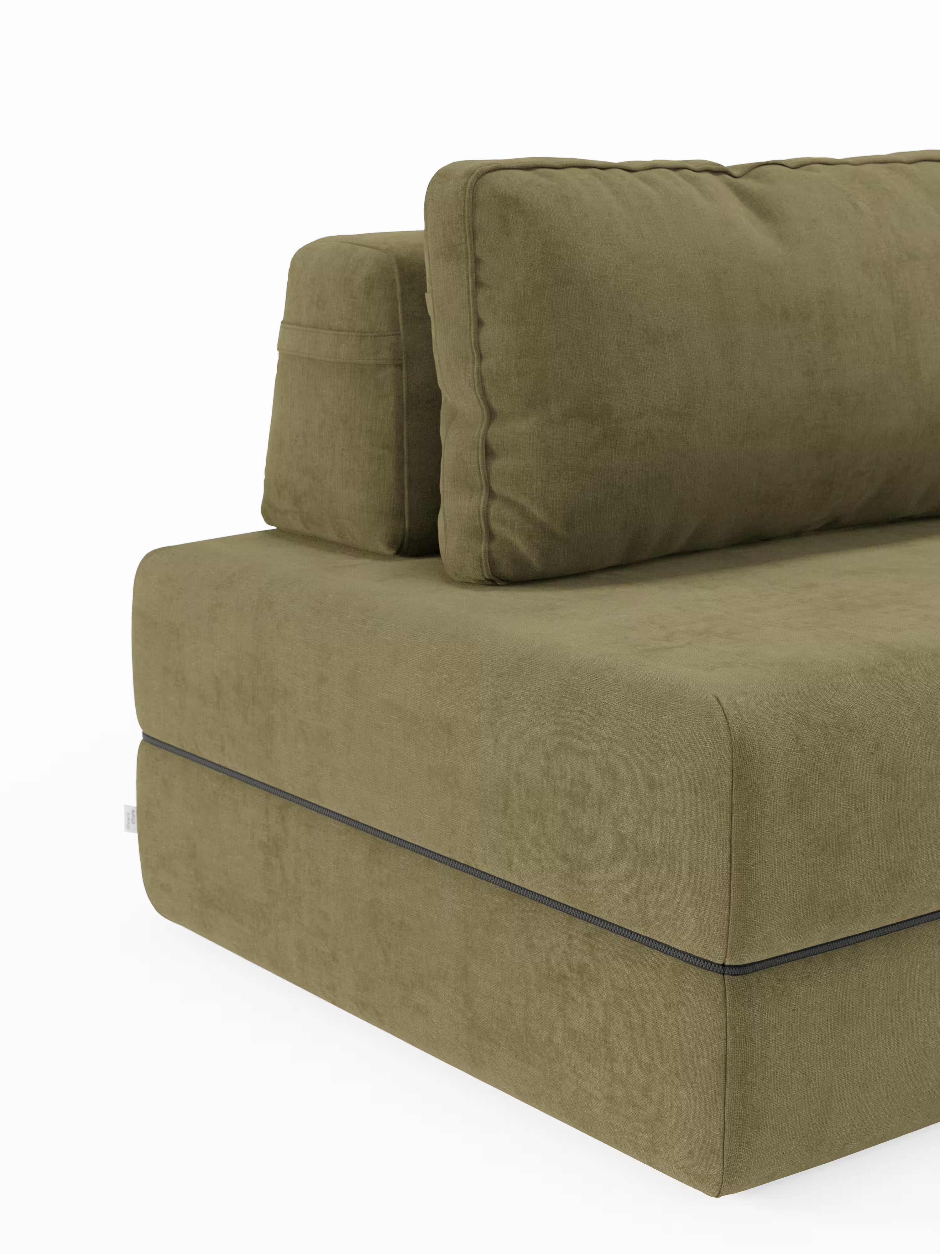 La poltrona letto Rift di Divani.Store presenta un design componibile in verde oliva con morbidi cuscini di seduta e schienale, cuciture a vista lungo i bordi e un tessuto T31 morbido, vellutato e antimacchia. Con un look sofisticato ispirato allo stile delle poltrone letto, questo modello si distingue per lo schienale mobile e il materasso in memory foam alto 22 cm. Il divano è posizionato ad angolo su un lato, in risalto su uno sfondo bianco.