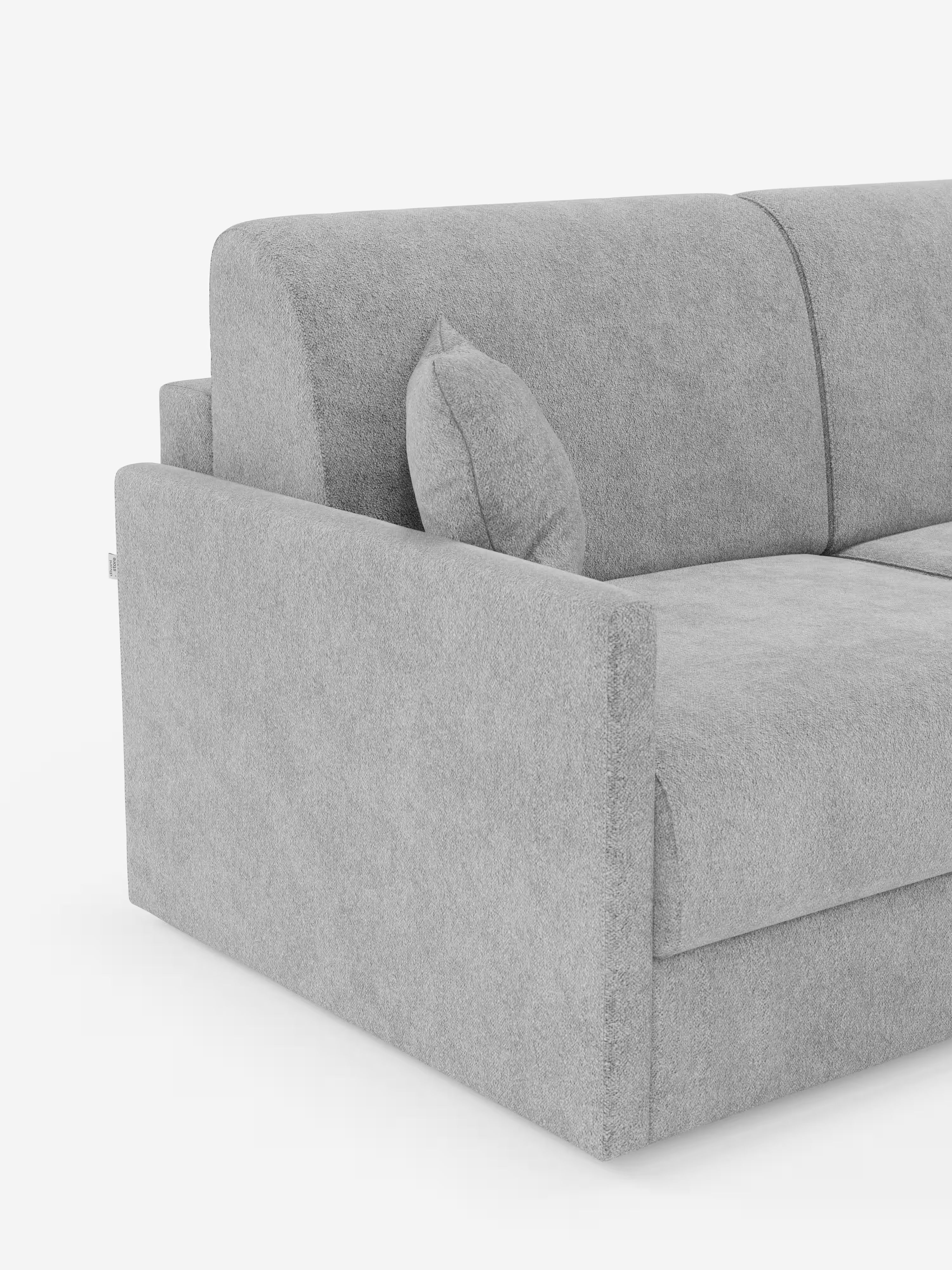 Un primo piano del divano letto Tommy Divano a 2 e 3 posti matrimoniale di Divani.Store ne mette in risalto il design moderno e minimalista in grigio chiaro, realizzato in tessuto T33 simile al cotone, 100% sfoderabile e antimacchia. L’immagine mette in risalto le linee pulite, l’imbottitura rigida, il bracciolo a sinistra e un cuscino decorativo abbinato su uno sfondo bianco: solo una parte di questo divano letto contemporaneo è visibile, il che ne sottolinea il fascino elegante.