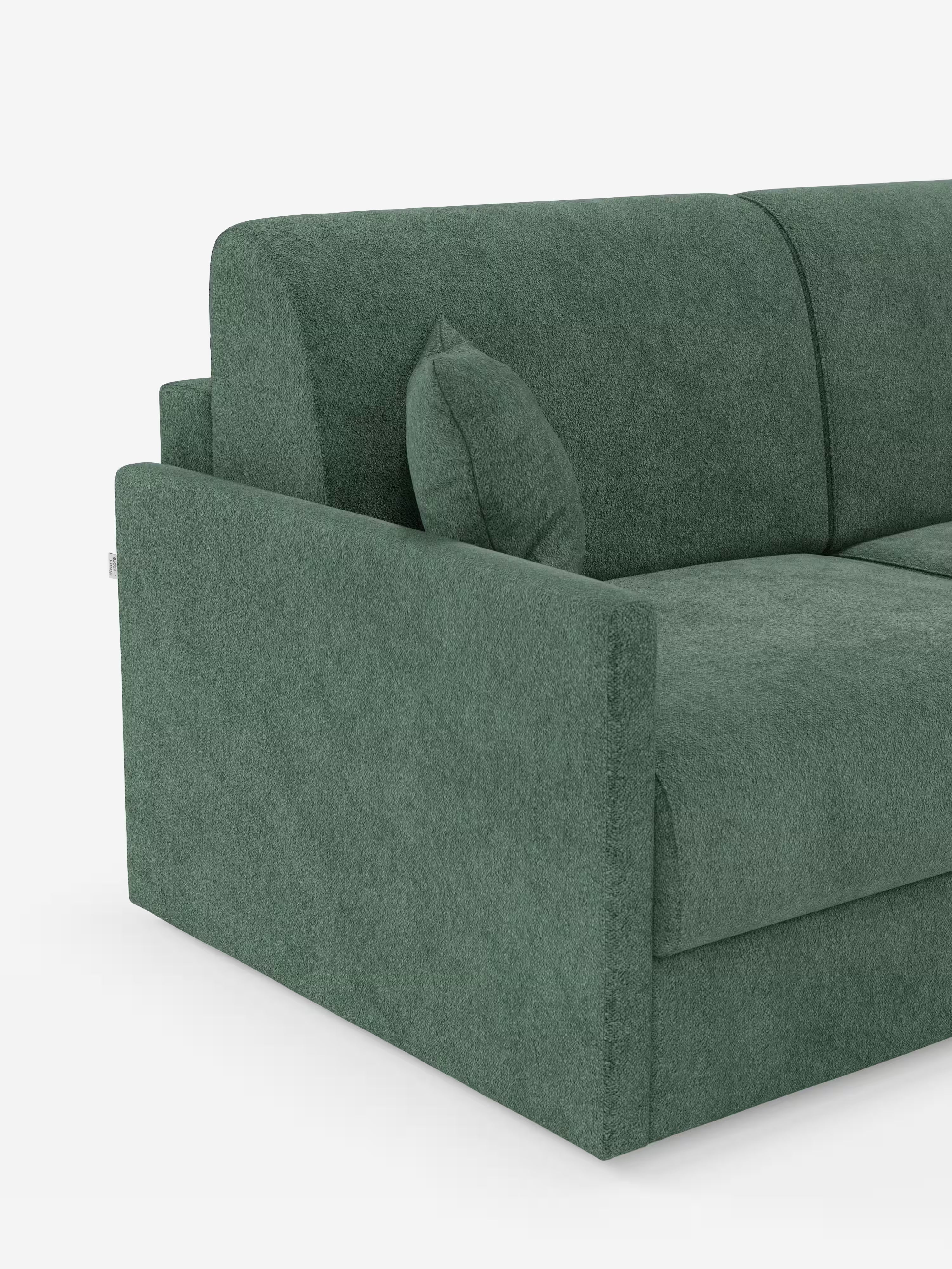 Un primo piano del divano letto Tommy Divano a 2 e 3 posti matrimoniale di Divani.Store, rivestito in morbido tessuto verde T33 effetto cotone, con trama a rilievo e facile da pulire. L'immagine mette in risalto il lato sinistro con bracciolo quadrato, schienale, cuscino di seduta e un cuscino decorativo abbinato. Caratterizzato da braccioli sottili che ne definiscono la silhouette moderna, questo divano con rivestimento rimovibile al 100% è ripreso su uno sfondo bianco a tinta unita.