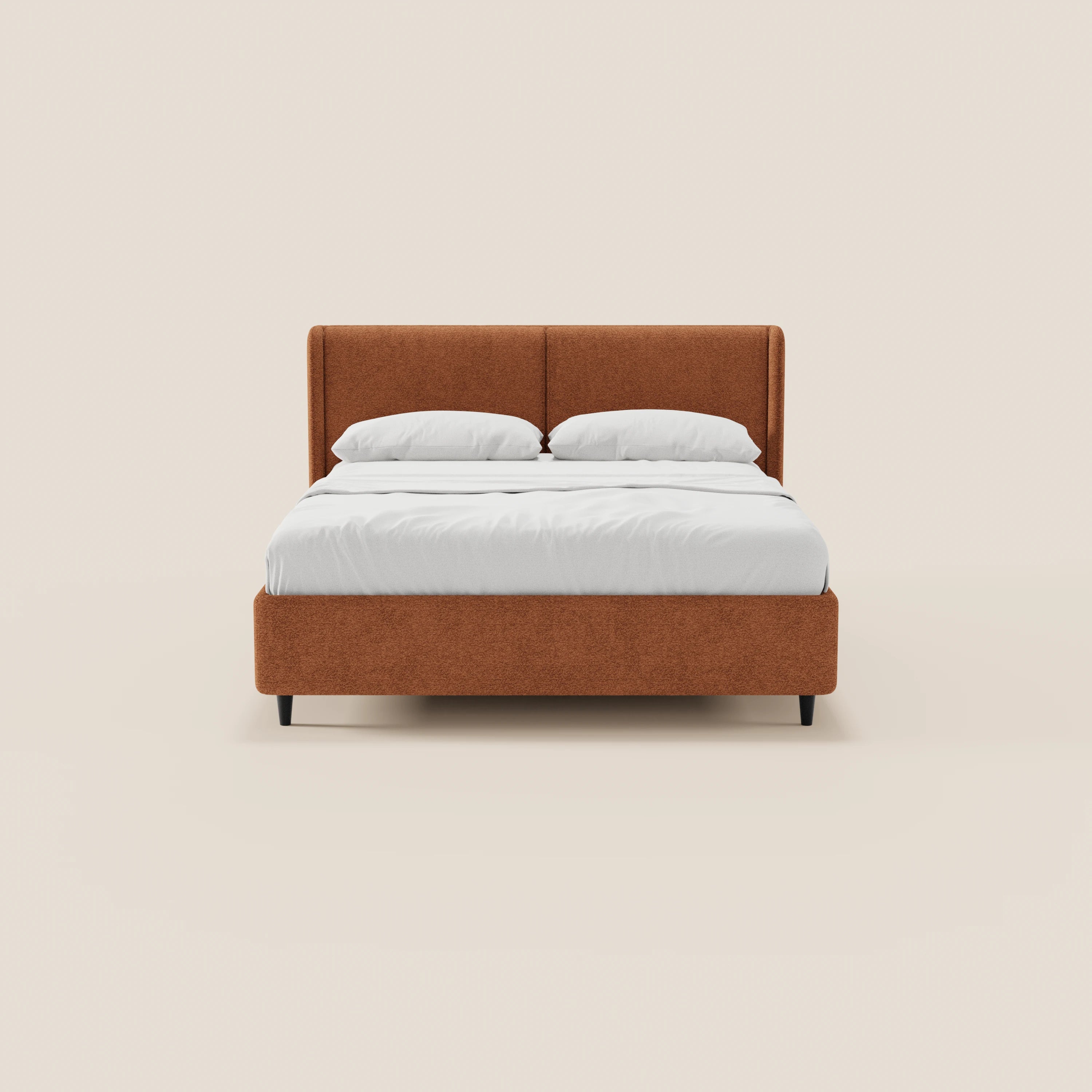 Il modello VALKIRIA di Letti.store è un letto di design con contenitore, testiera avvolgente rivestita in tessuto Oeko-Tex® color ruggine, 2 cuscini imbottiti, lenzuola e cuscini bianchi e gambe nere sottili su sfondo crema.