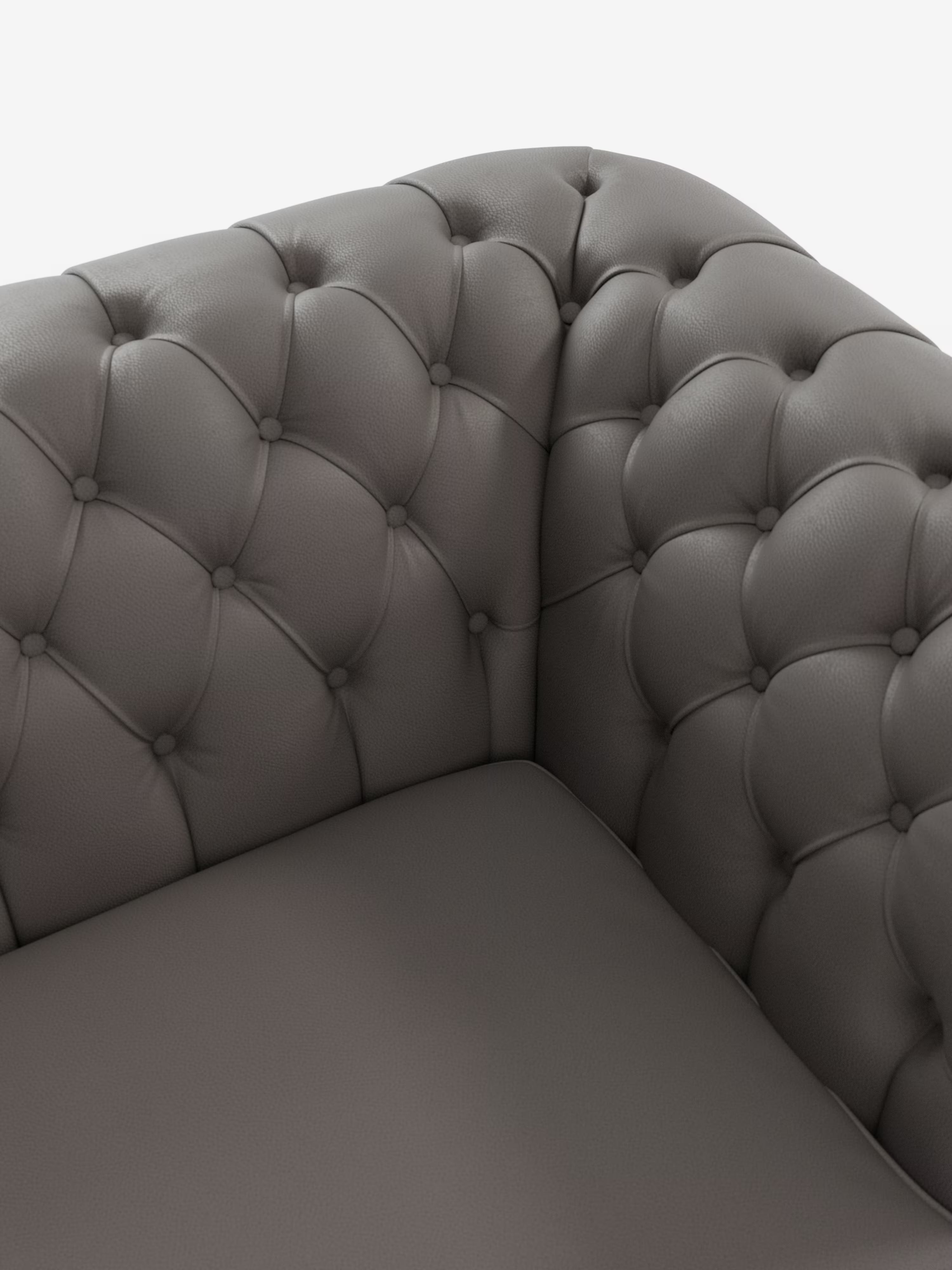 Primo piano dell'angolo di un Chester grigio – Divano Chesterfield in vera pelle spessorata a 2 e 3 posti di Divani.Store, caratterizzato da una profonda trapuntatura a bottoni e da un cuscino di seduta morbido e imbottito su uno sfondo bianco a tinta unita, che esalta l'eleganza senza tempo di questo classico divano in pelle.