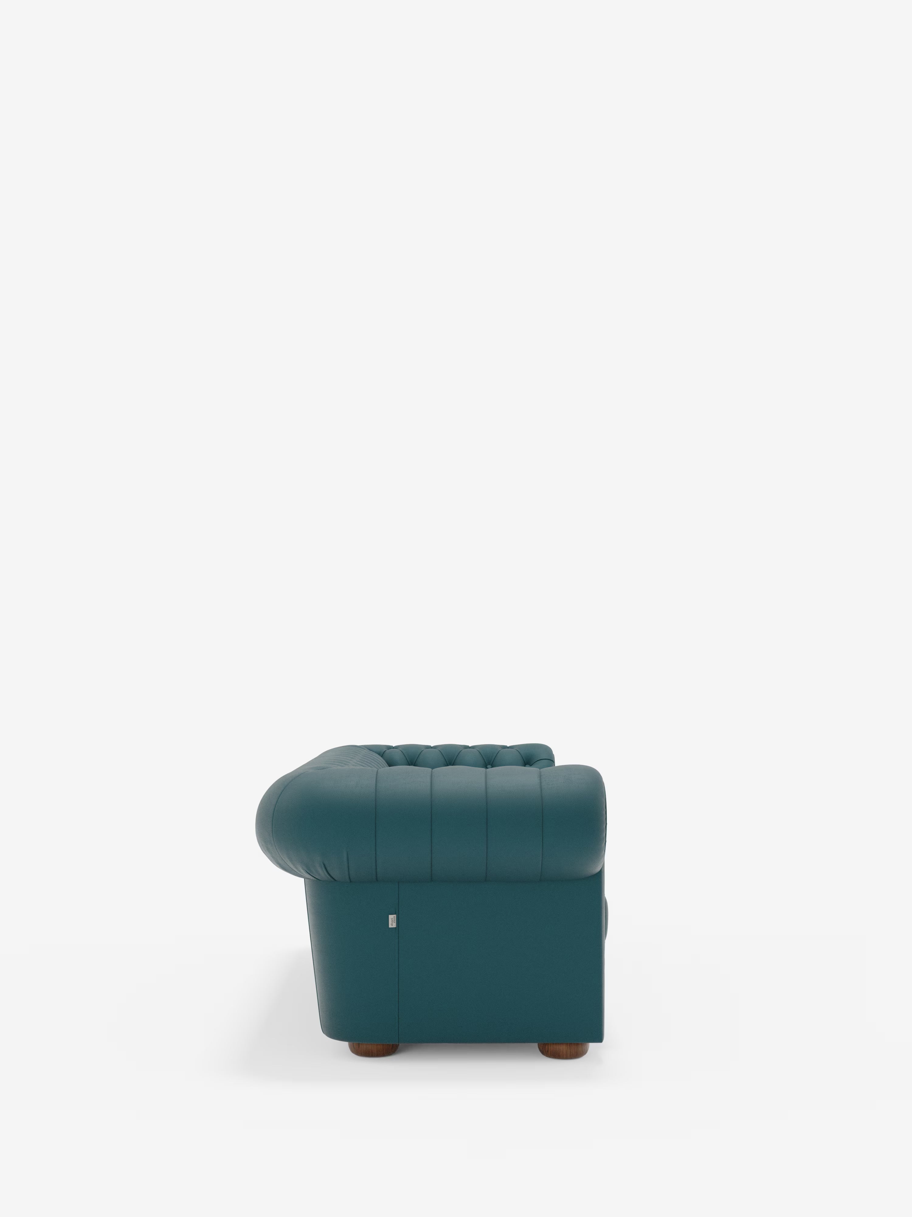 Su uno sfondo bianco è raffigurato il profilo laterale del Chester – divano Chesterfield in vera pelle spessorata a 2 e 3 posti di Divani.Store. Questo divano artigianale Made in Italy presenta braccioli arrotondati e trapuntati che si abbinano perfettamente allo schienale imbottito, ed è sostenuto da piedini corti in legno.