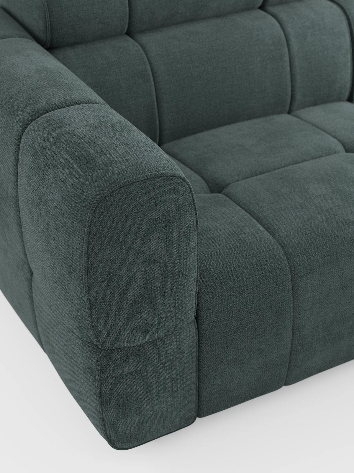Un primo piano del divano modulare Giotto a 4 posti, color grigio antracite, con poggiatesta reclinabili e funzione relax elettrica opzionale, rivestito in tessuto smacchiabile T23, caratterizzato da braccioli spessi e arrotondati e da cuscini profondi con trapuntatura quadrata su uno sfondo bianco a tinta unita.