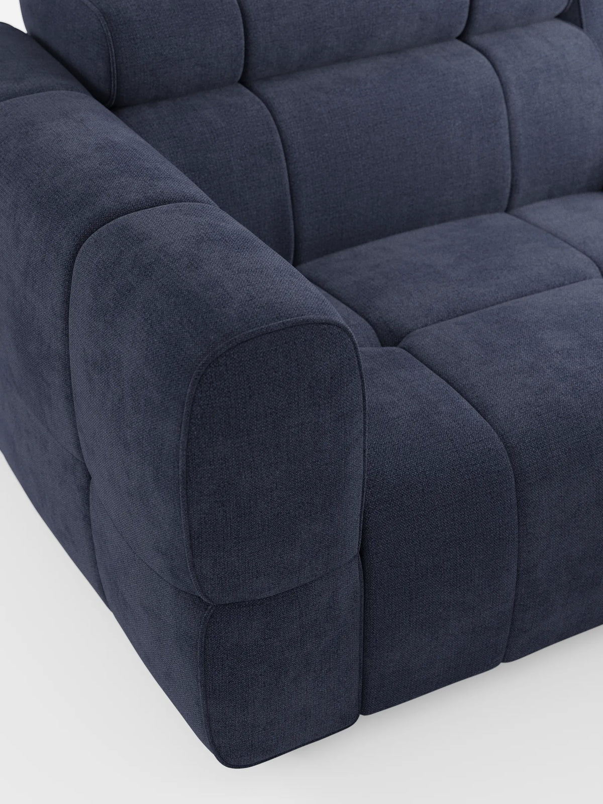 Il divano modulare Giotto a 3 posti, con poggiatesta reclinabili e funzione relax elettrica opzionale, rivestito in tessuto smacchiabile T23, è un divano modulare a tre posti di colore blu scuro, caratterizzato da una struttura a griglia di pannelli imbottiti, braccioli bassi e spessi e un design moderno e raffinato.
