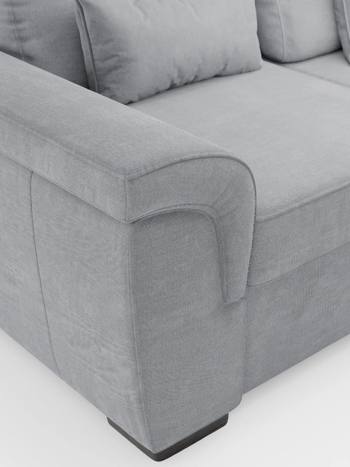 Il divano Ischia a 3 posti con pouf estraibile e schienali traslanti in tessuto misto lino smacchiabile è un divano a 3 posti di colore grigio chiaro con trama a rilievo, braccioli ricurvi, cuscini dello schienale in tinta e piedini corti e rettangolari di colore scuro su fondo bianco.