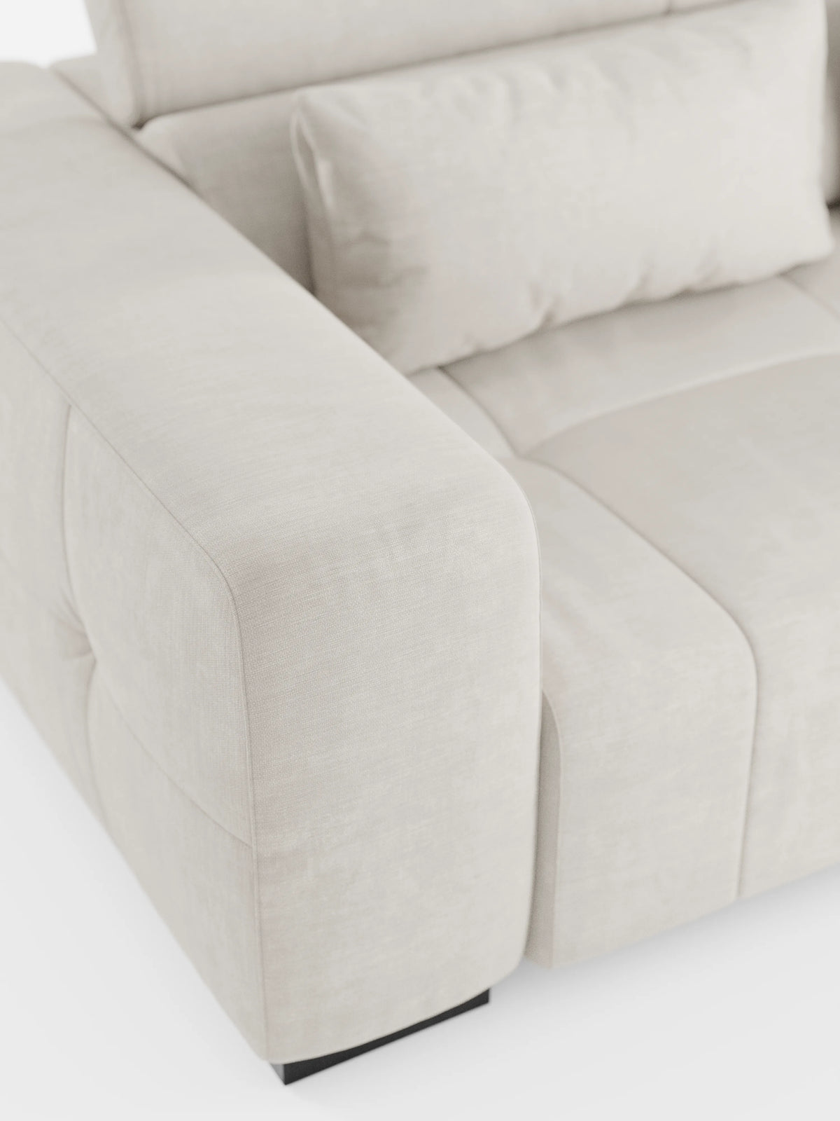 Primo piano del divano angolare Monarch con penisola e sistema Relax elettrico per l’allungamento delle sedute di Divani.Store, rivestito in morbido tessuto T31 resistente alle macchie. Questo moderno divano color beige chiaro presenta ampi braccioli imbottiti, morbidi cuscini dello schienale con cuciture a vista e poggiatesta regolabili. Ispirato al design italiano dei divani relax elettrici, poggia su gambe corte di colore scuro e si distingue per la sua texture accogliente e il fascino contemporaneo.