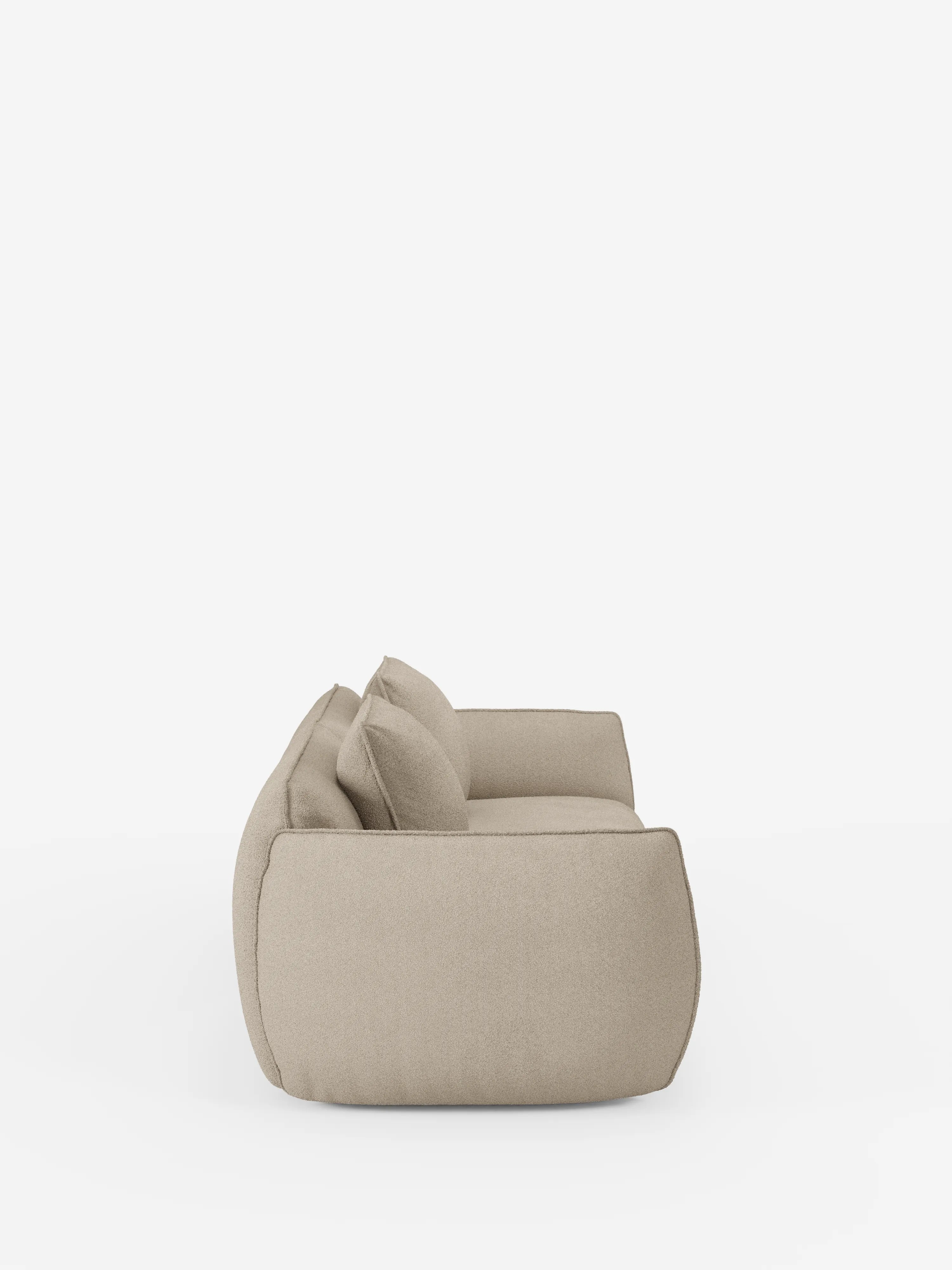 Divano Nimbus a 3 posti, modulare e componibile, 250 cm, di Divani.Store: modello beige, moderno e dalle linee sobrie, ripreso di profilo su sfondo bianco. Questo divano presenta un aspetto morbido e lussuoso, con due grandi cuscini di seduta e due cuscini dello schienale abbinati. Caratterizzato da bordi arrotondati e da un design contemporaneo minimalista, è rivestito in tessuto sfoderabile effetto cotone resistente alle macchie (t33).